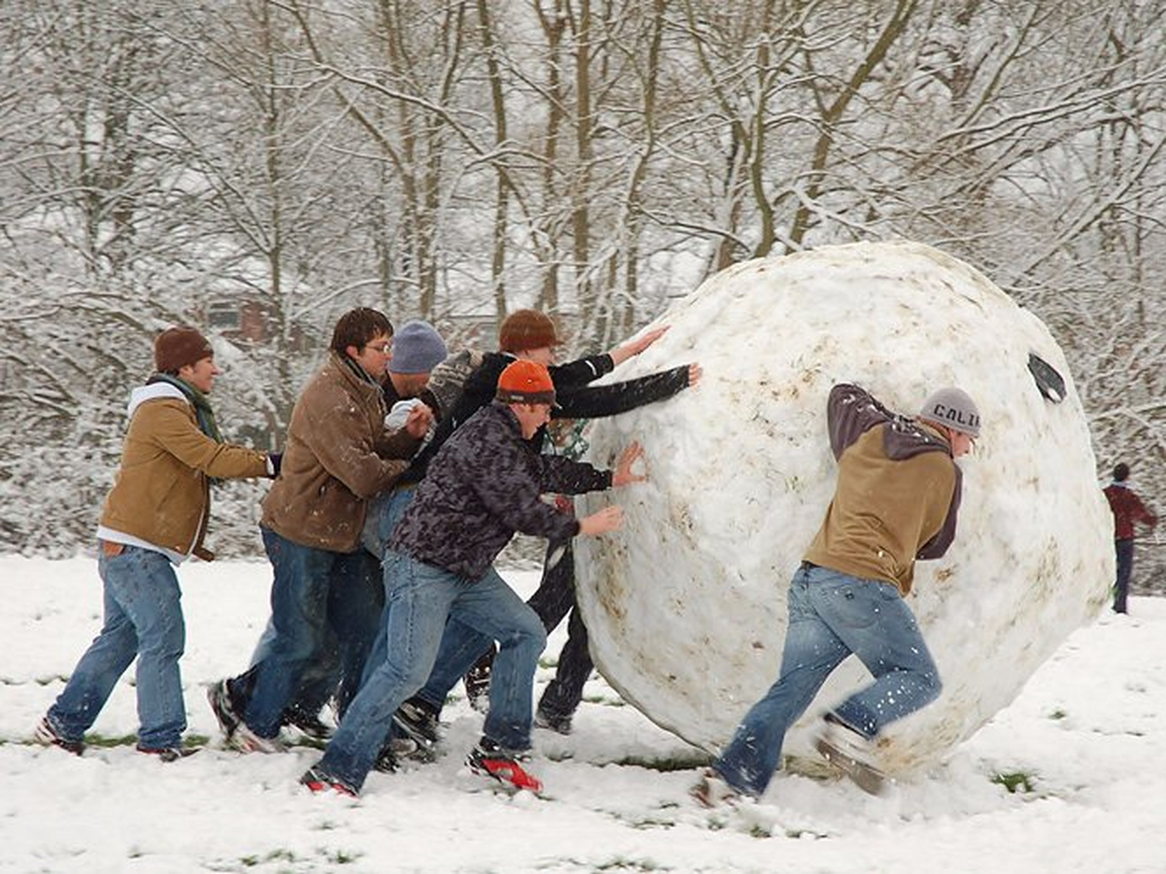 [re] Unos chicos jóvenes juegan con una bola de nieve