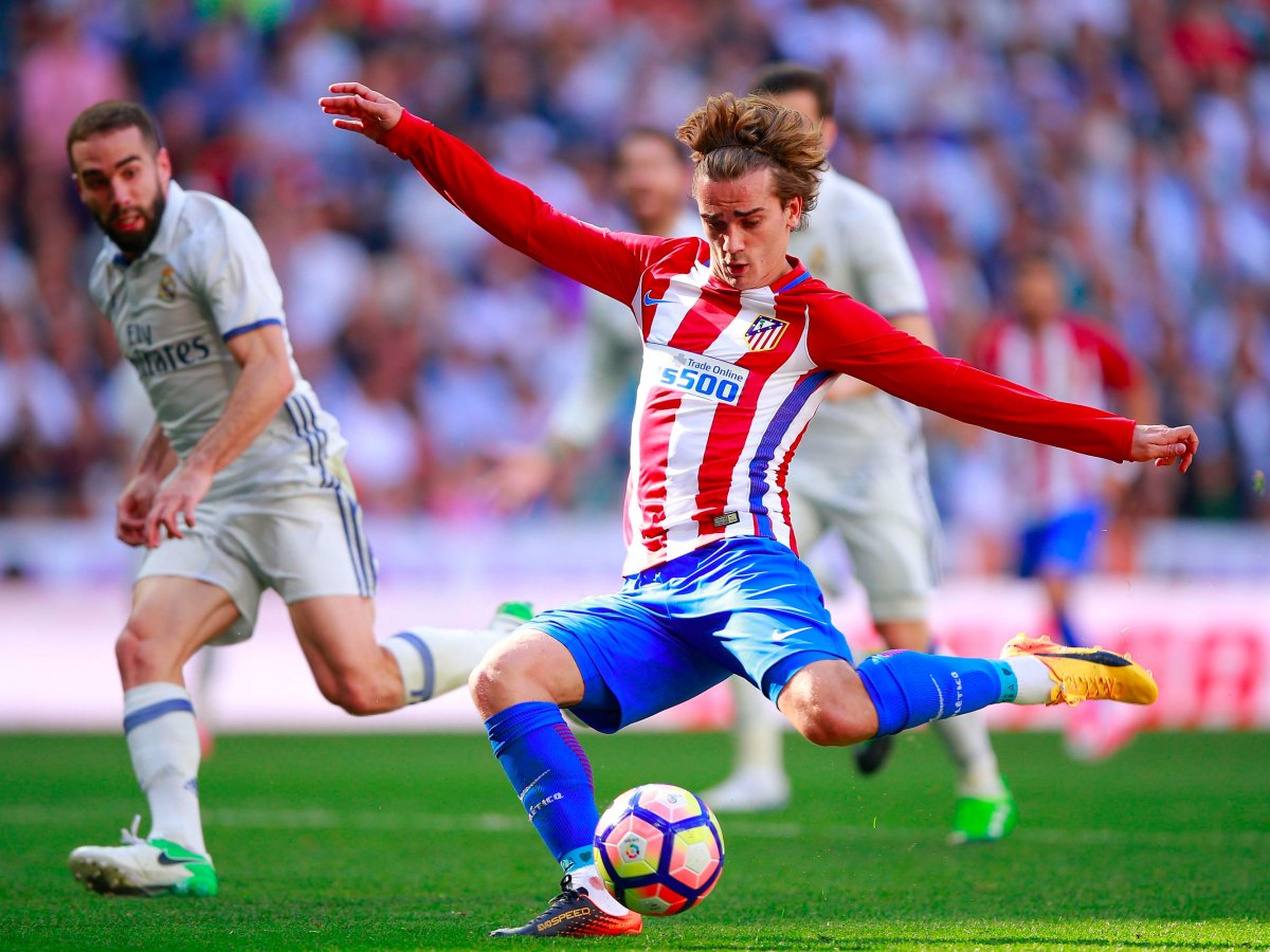 El jugador de fútbol Antoine Griezmann, del Atlético de Madrid, realiza un disparo contra el Real Madrid.
