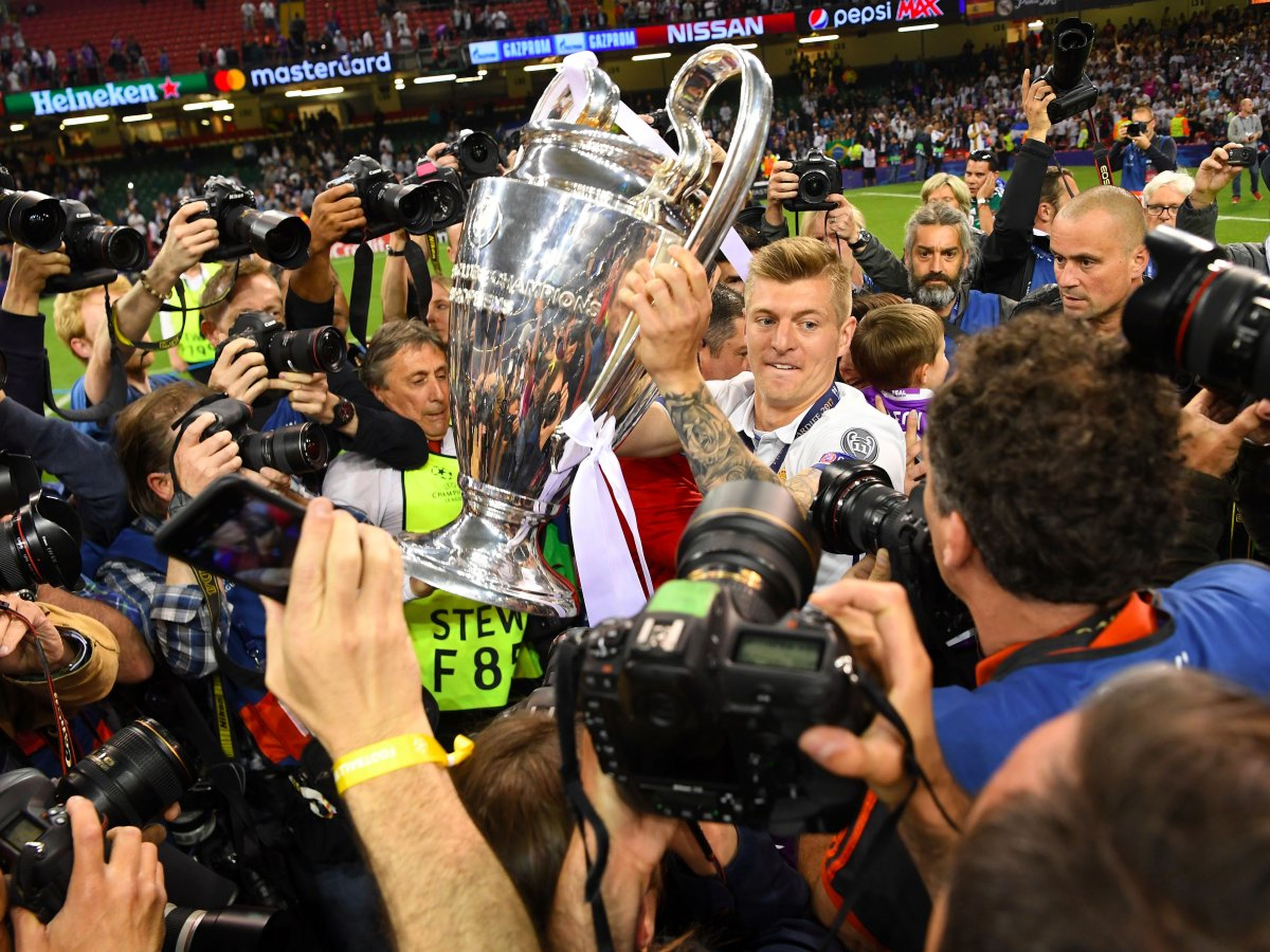 El jugador de fútbol del Real Madrid Toni Kroos se abre paso entre los fotógrafos con la Champions League 2017.