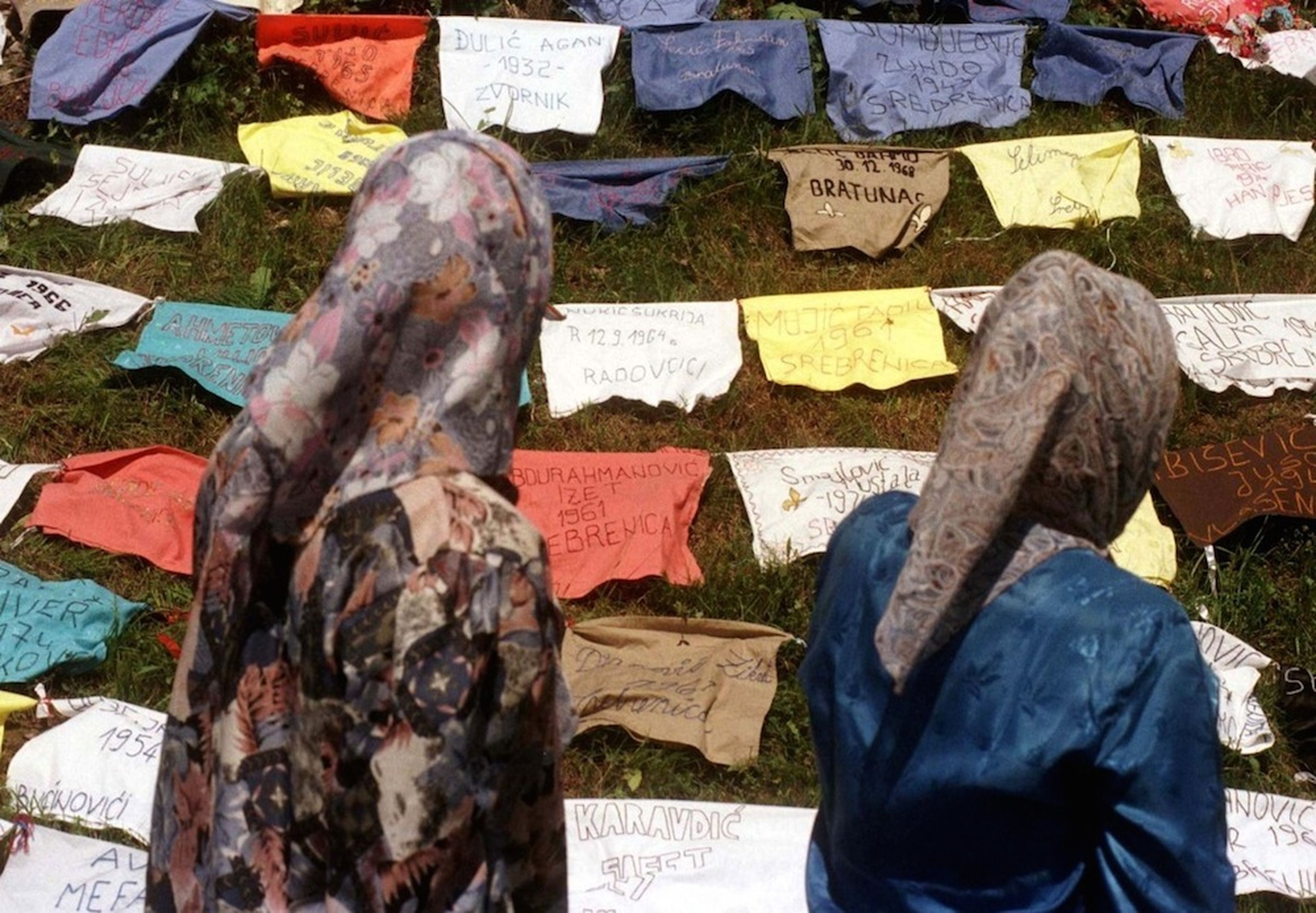 Mujeres refugiadas leen los nombres de desaparecidos escritos sobre almohadas el 18 de julio de 1995, cerca de la ciudad bosnia de Kladanj.