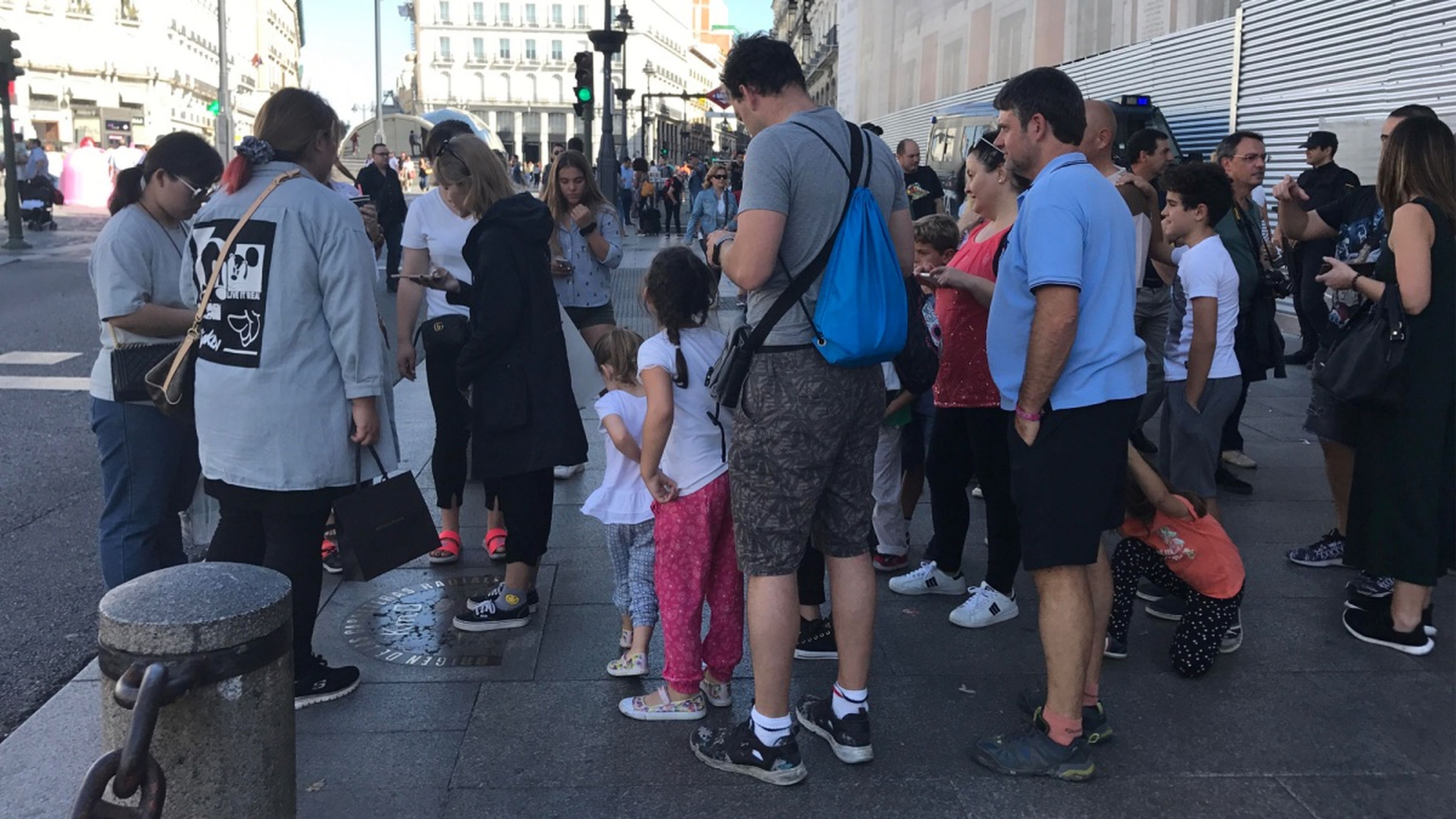 Turistas esperando a hacerse una foto en el km 0 de la Puerta del Sol