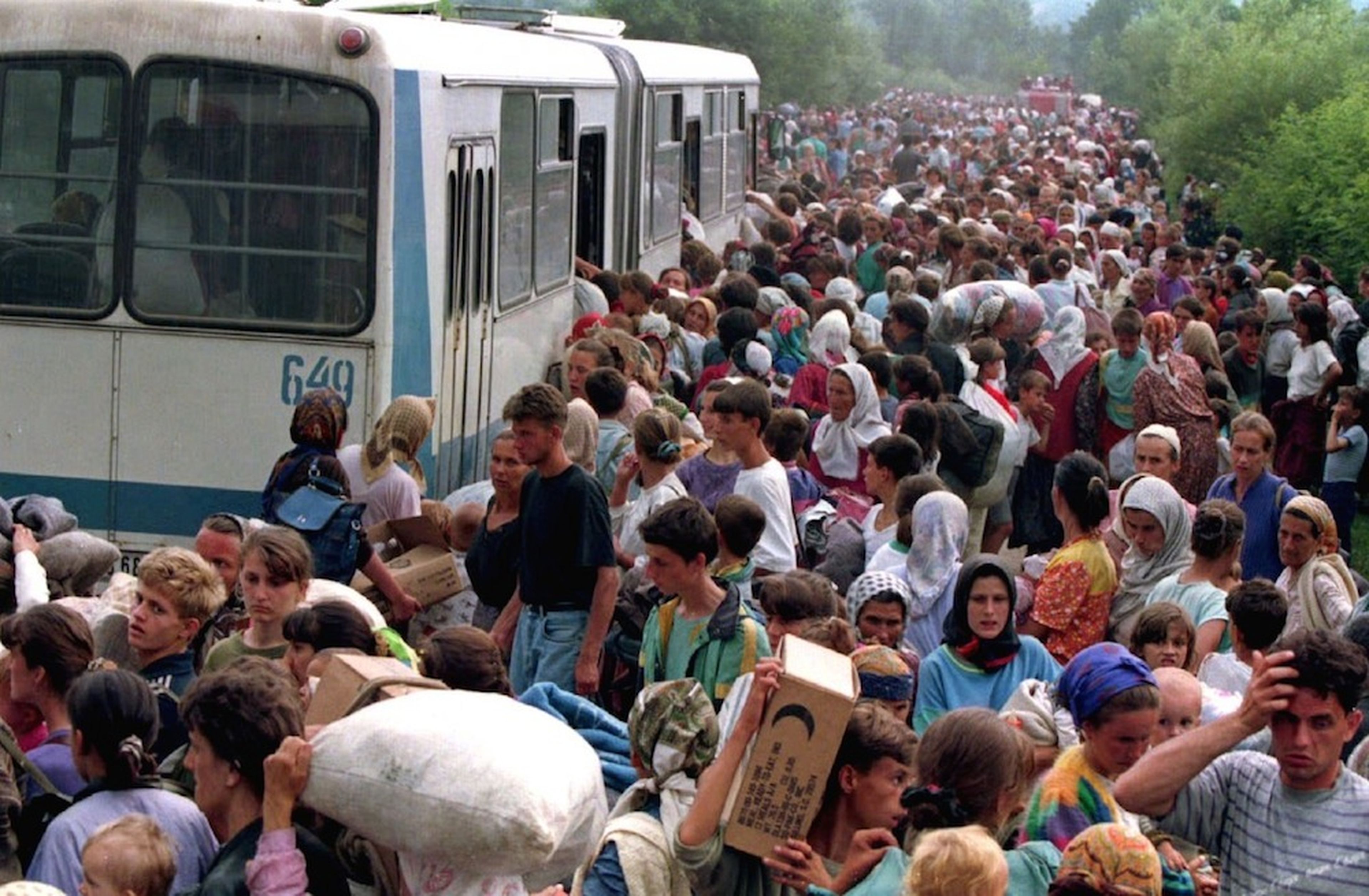 Unos 10.000 refugiados de Srebrenica, fuera de la base de la ONU en el aeropuerto de Tuzla, accediendo a los autobuses que habían de distribuirlos en otros campamentos de refugiados de la zona, el 14 de julio de 1995.