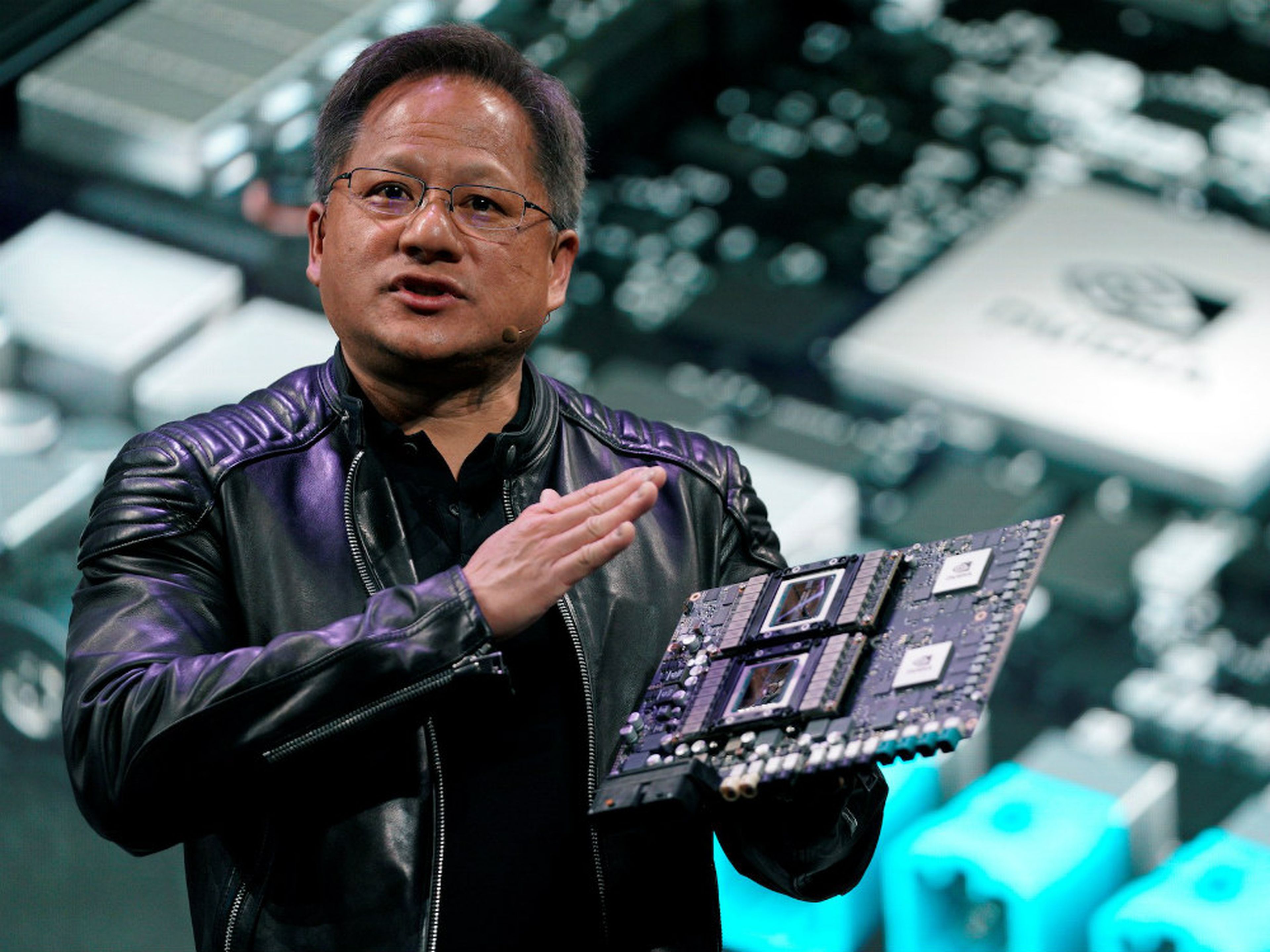 El CEO de Nvidia, Jensen Huang, muestra la placa base de su robotaxi Drive Pegasus durante su intervención en la feria CES de 2018.