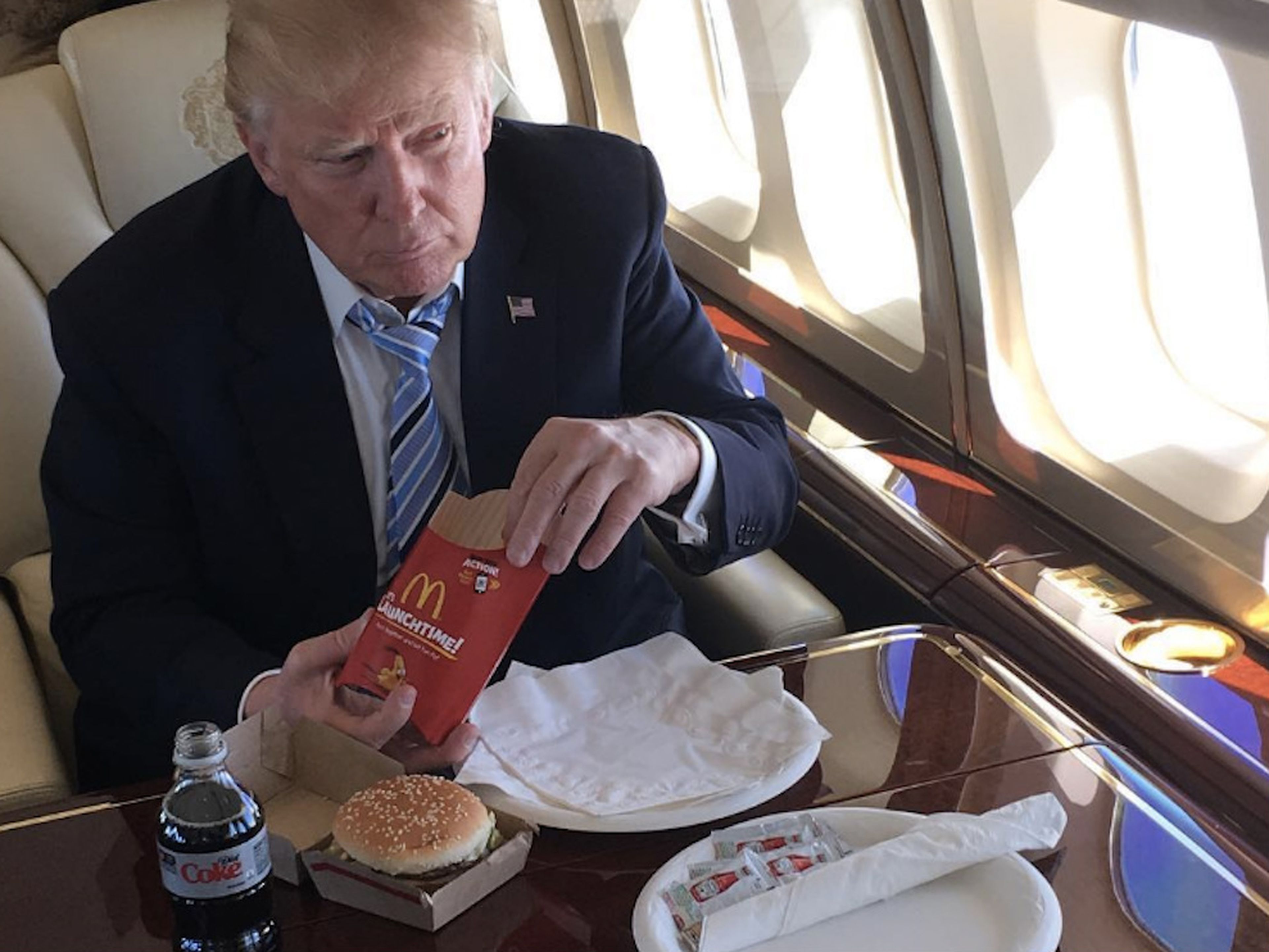 Donald Trump comiendo patatas y hamburguesas de McDonald's en su avión cuando era candidato a la presidencia de Estados Unidos.