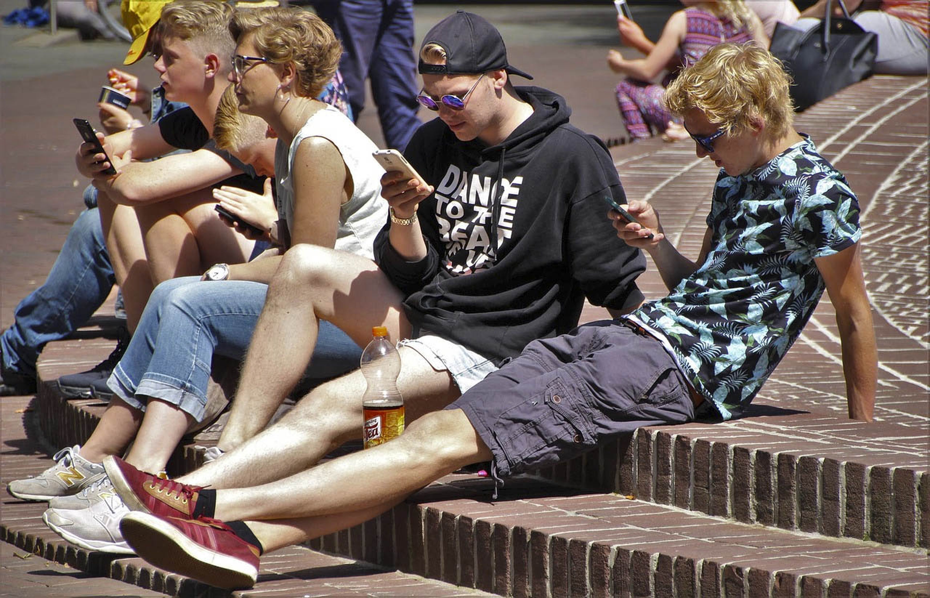 Jóvenes usando el móvil en la calle