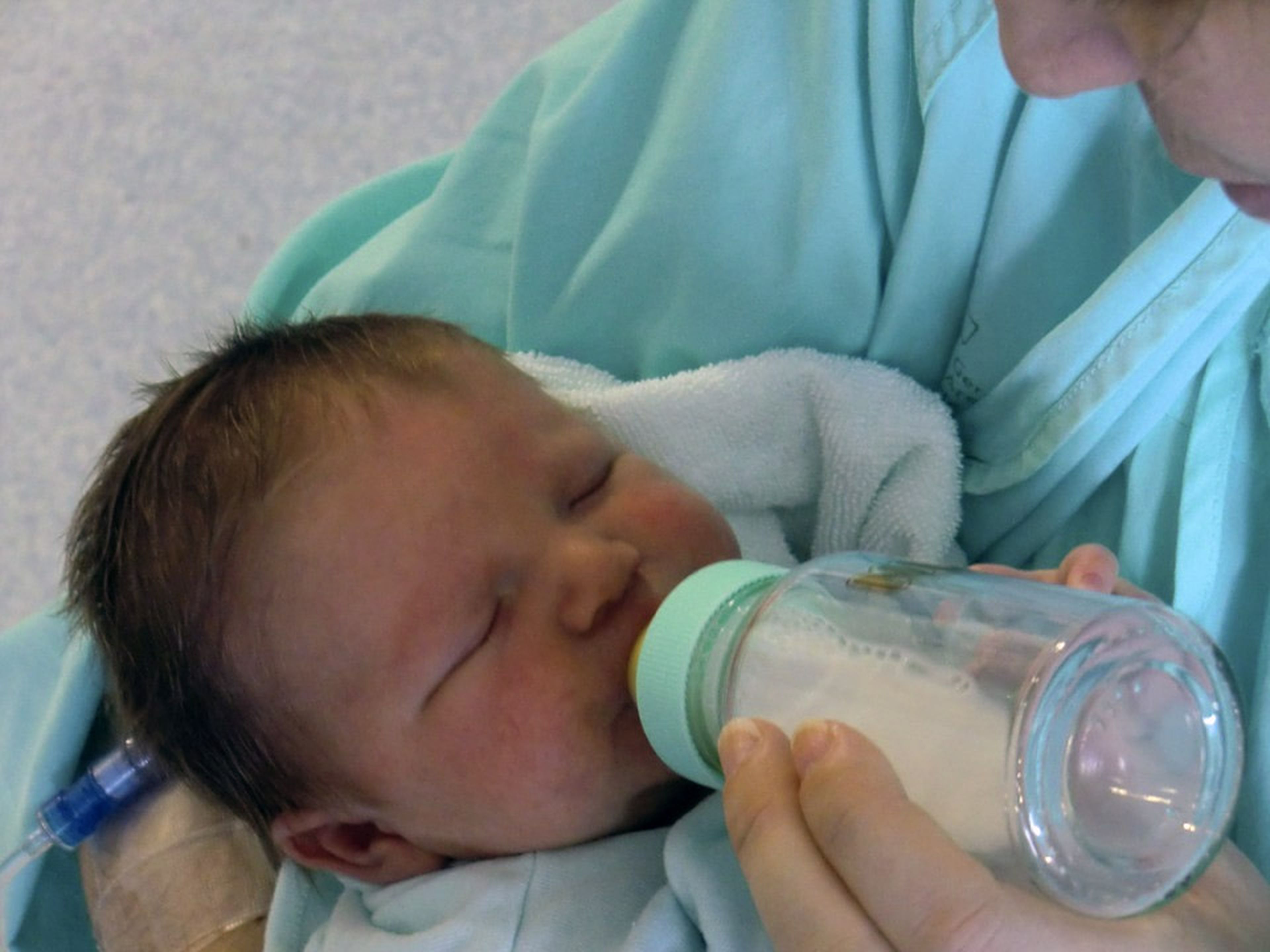 Bebé tomando leche materna en biberon