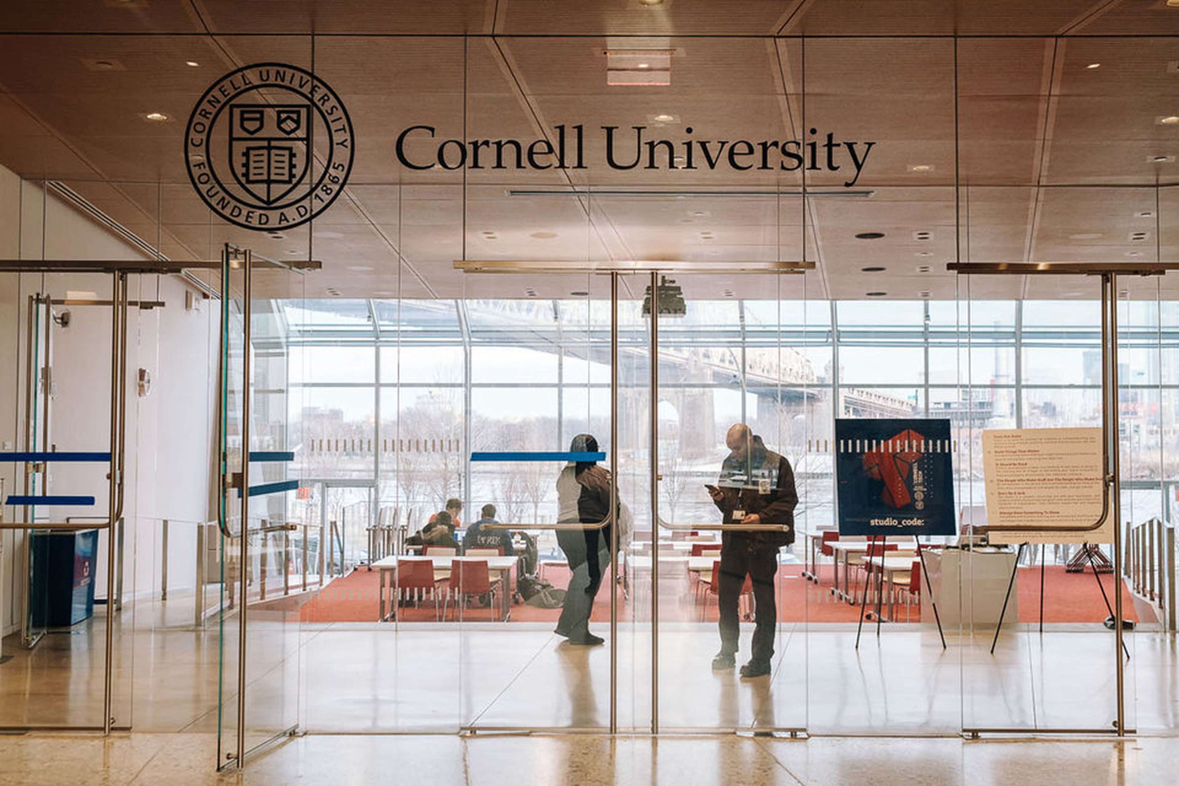 Vista del área de trabajo. Las pancartas muestran el "código de estudio" de Cornell Tech, que contiene preceptos como "Construye cosas que importen" y "No seas idiota"