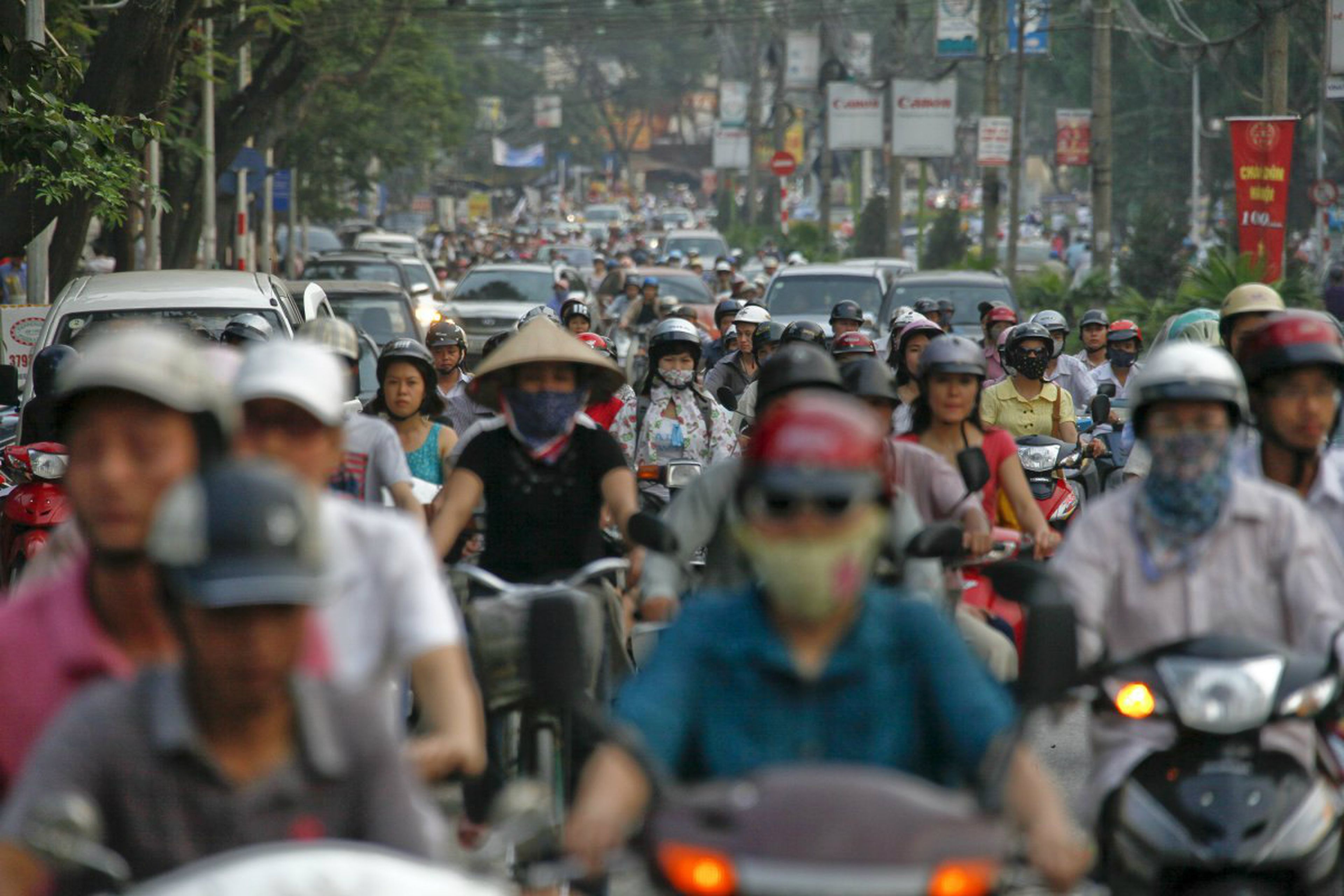 Bicis y coches circulan juntos por las carreteras de Hanói (Vietnam).