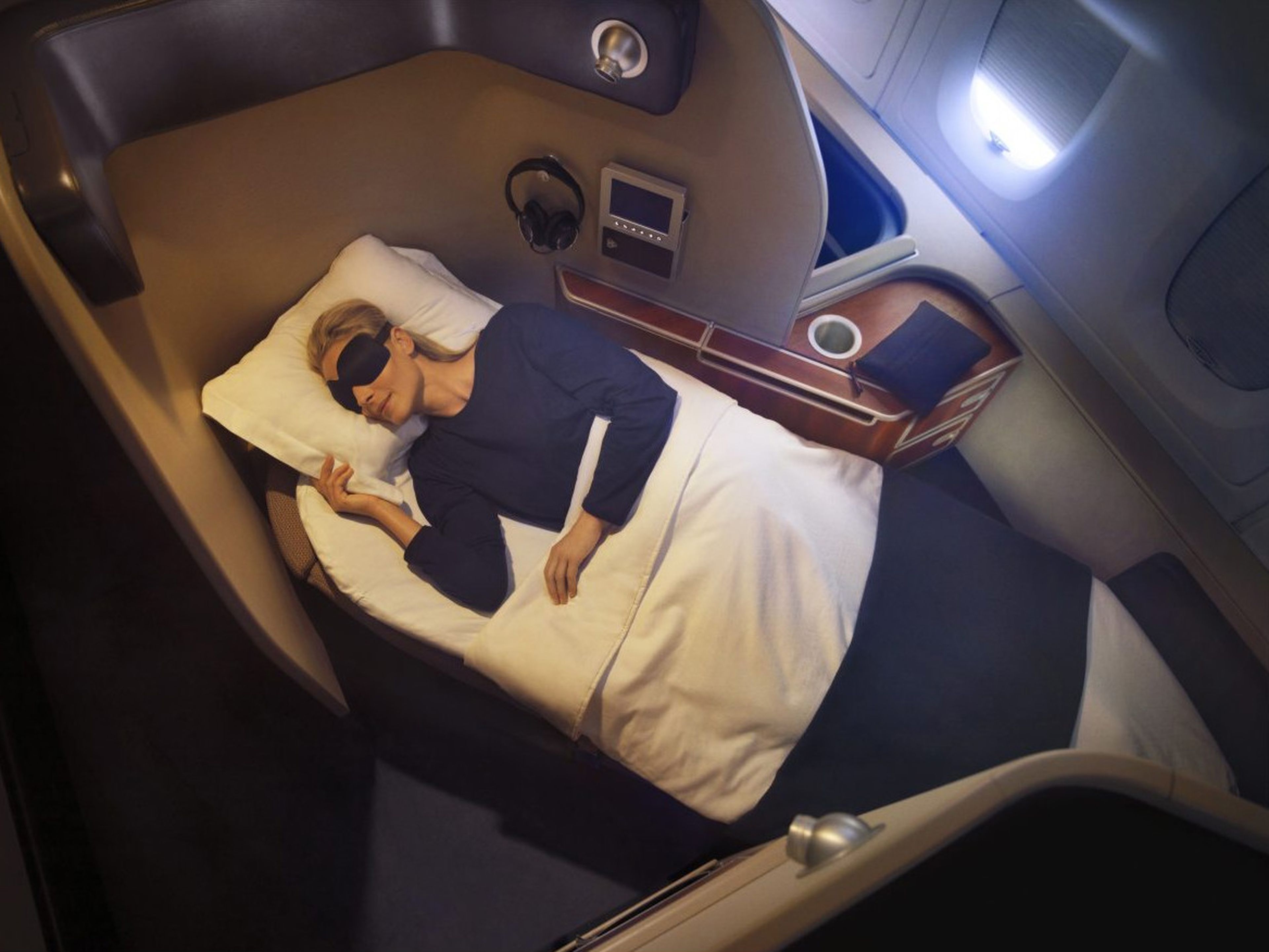 Una pasajera duerme en una cabina de primera clase durante un vuelo.