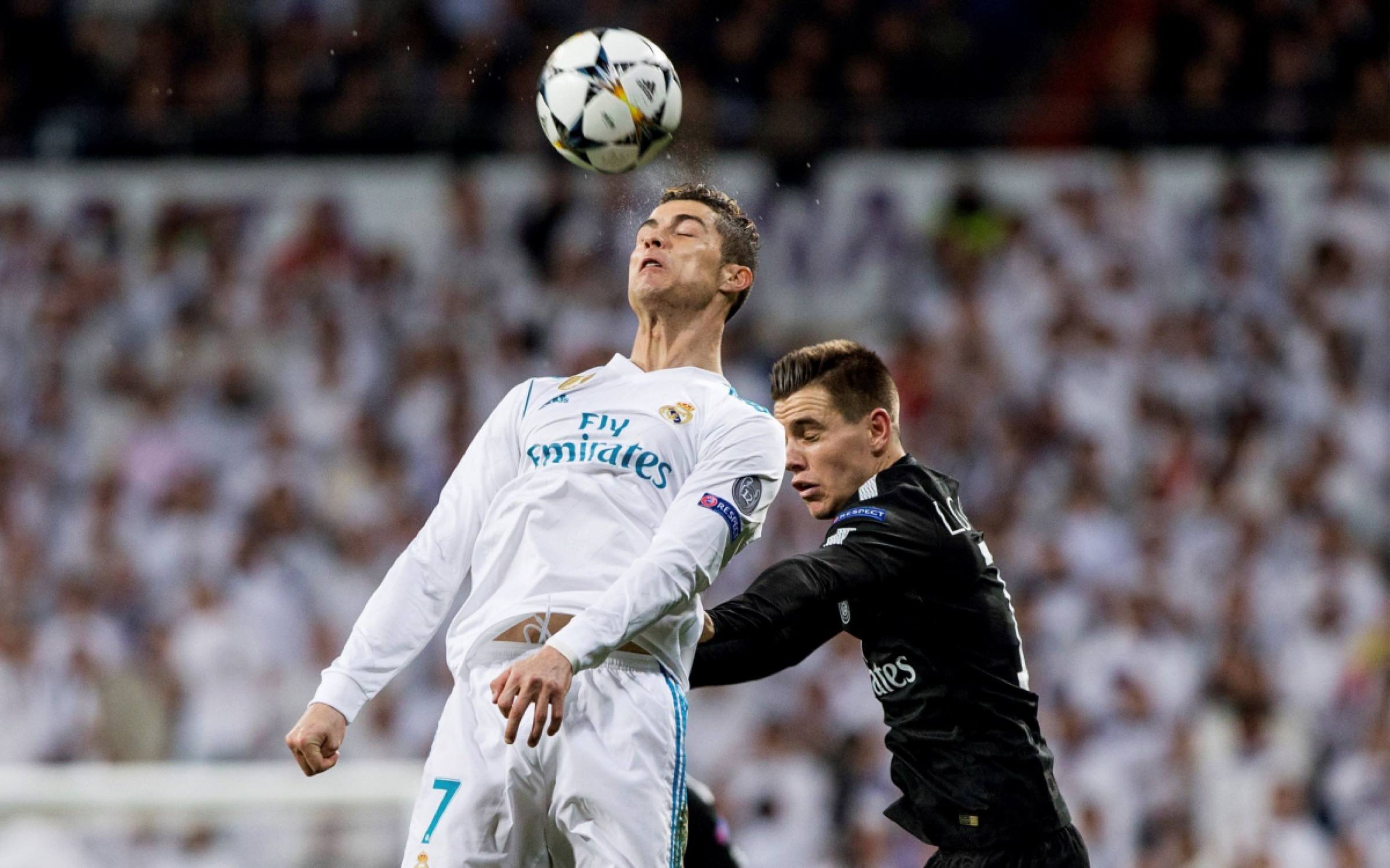 Cristiano Ronaldo, del Real Madrid, salta por el balón junto a Lo Celso, del Paris Saint Germain.