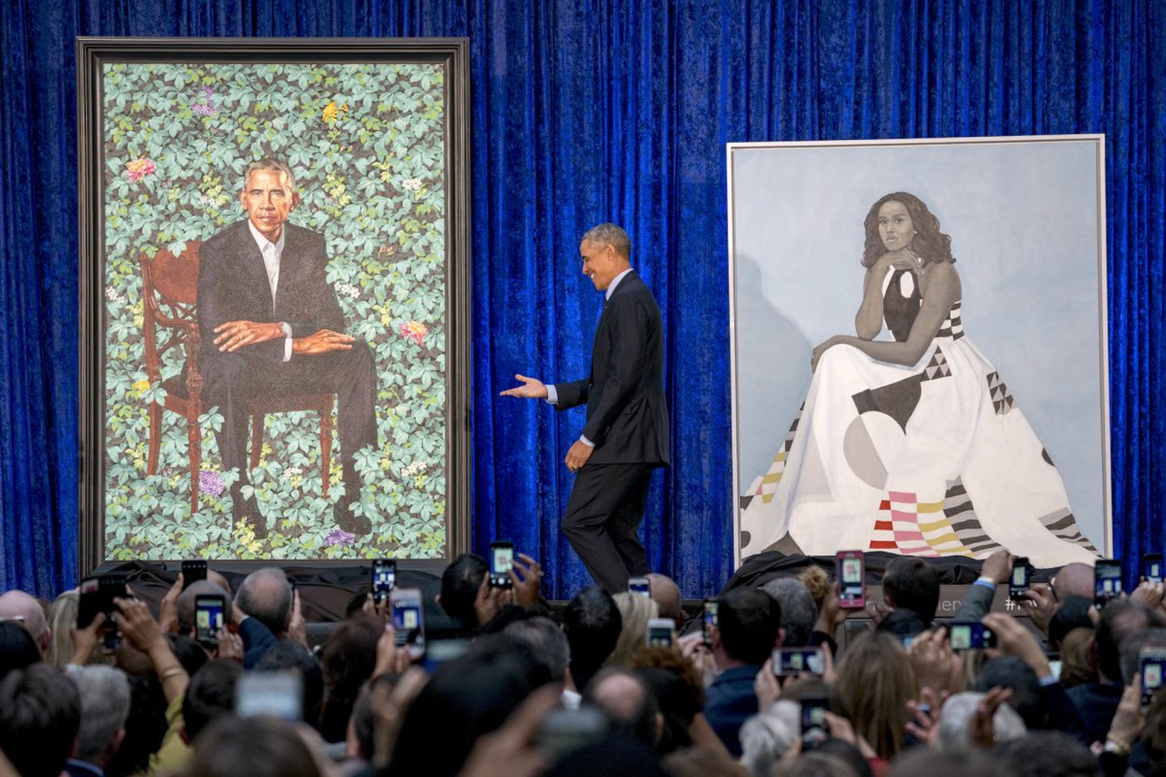 Obama junto su retrato y el de su mujer.