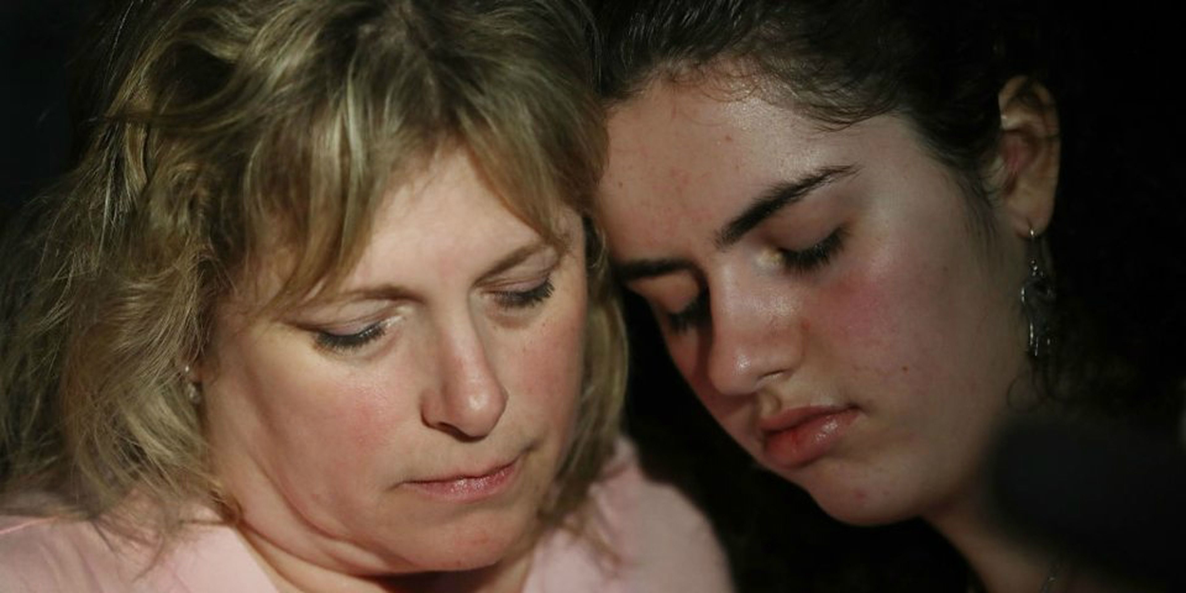 Sarah Crescitelli se apoya en su madre, Stacy Crescitelli (izqd.) tras escapar del tiroteo en la escuela secundaria Marjory Stoneman Douglas en el que murieron 17 personas el 14 de febrero de 2018 en Parkland, Florida (EE. UU.).