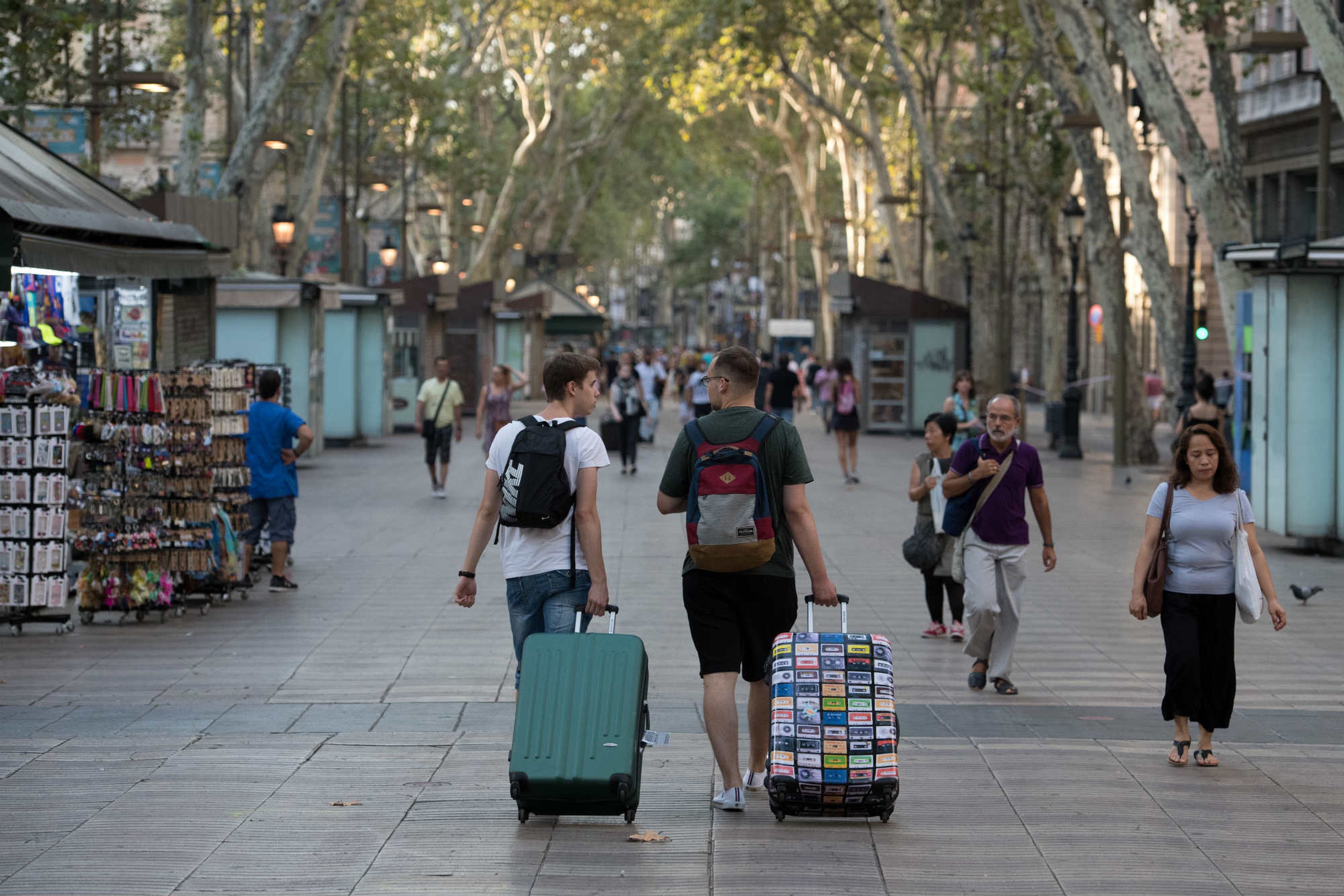 Unos turistas pasean por Las Ramblas de Barcelona.