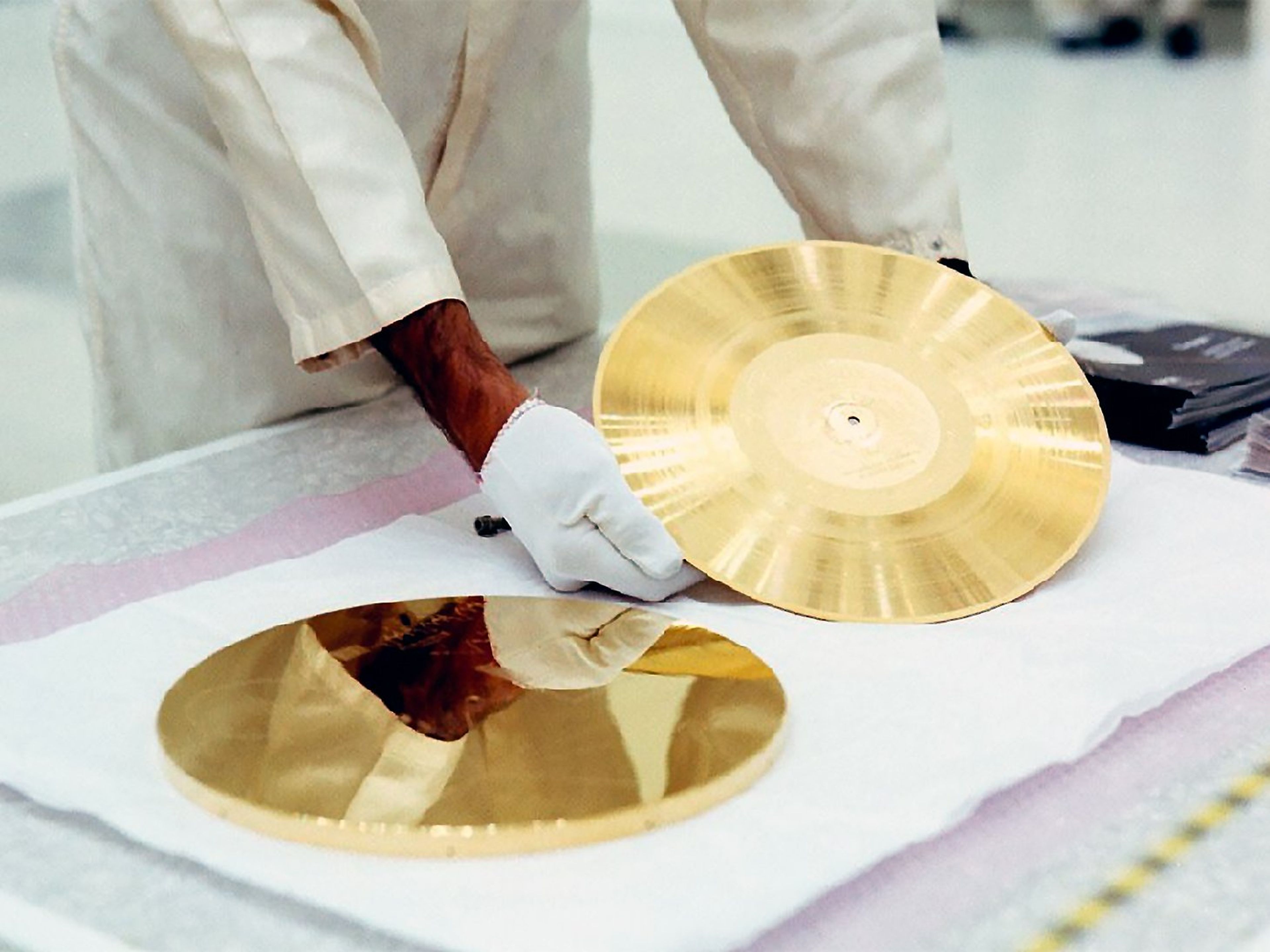 Un técnico de la NASA prepara un vinilo de oro para instalarlo en la sonda Voyager 1.