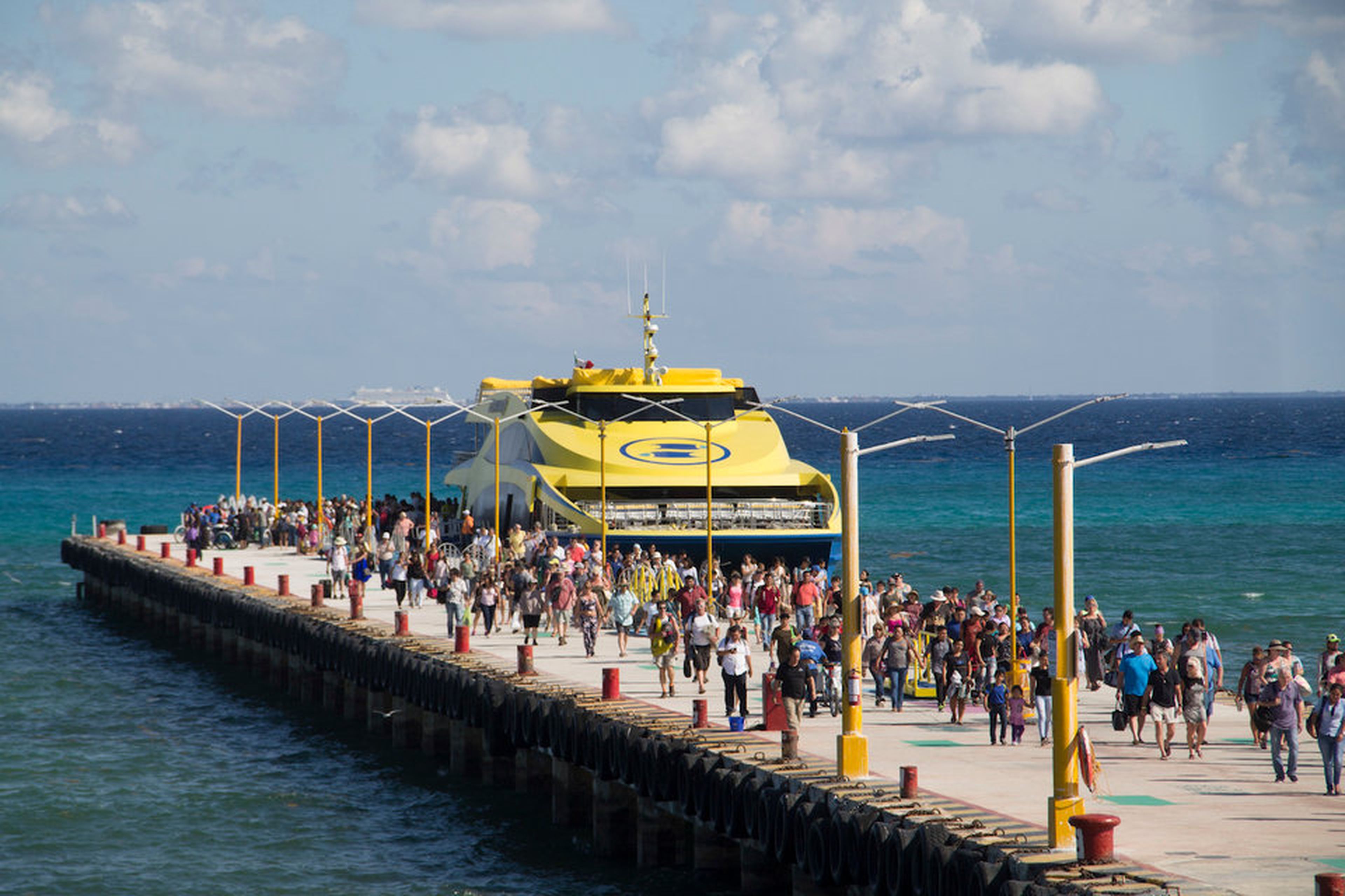 Tristas y pasajeros desembarcan de un ferry que llega a Playa del Carmen, México, el 2 de marzo de 2018.