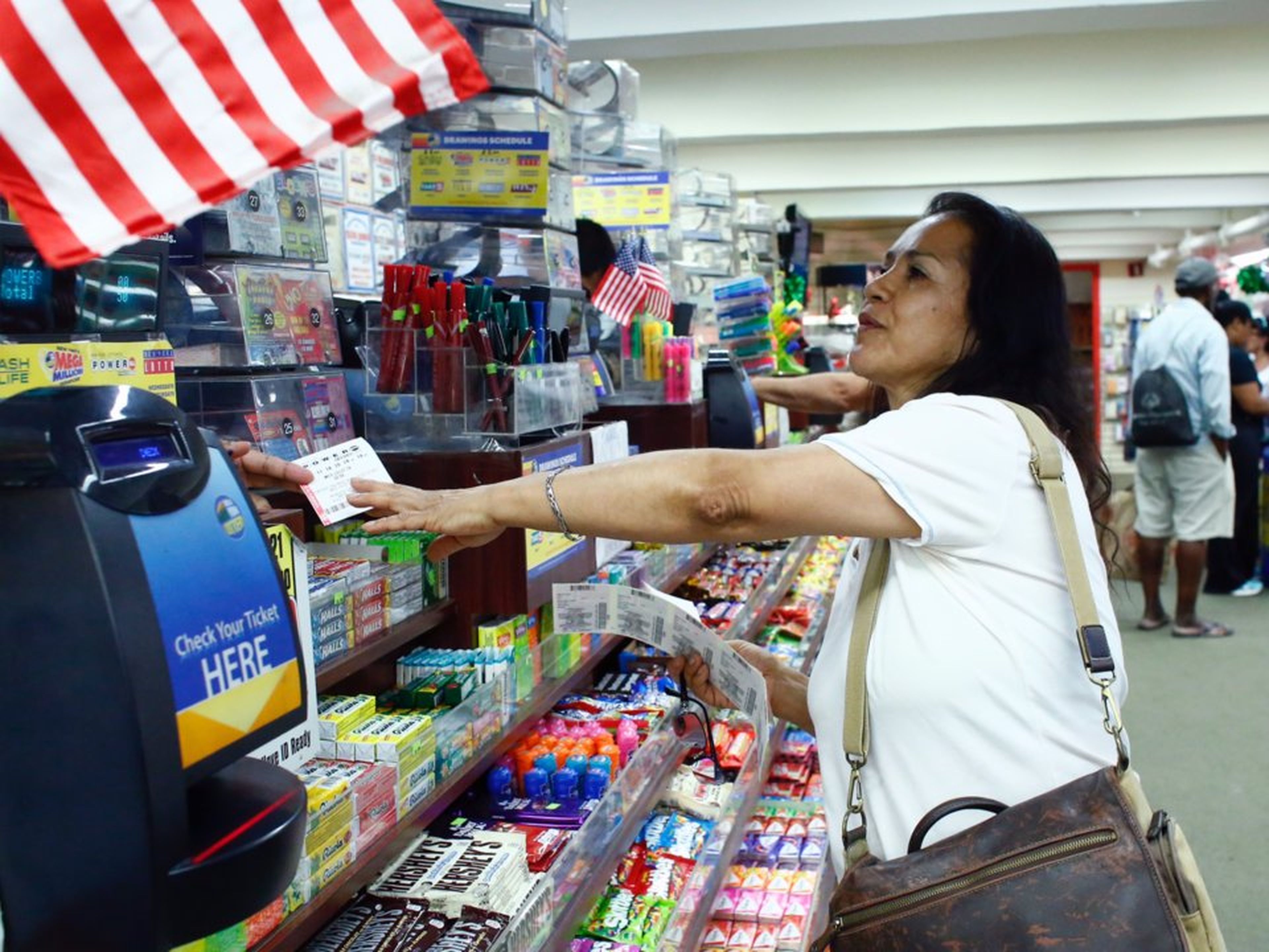 Una mujer compra un boleto de Powerball, juego de lotería americana.