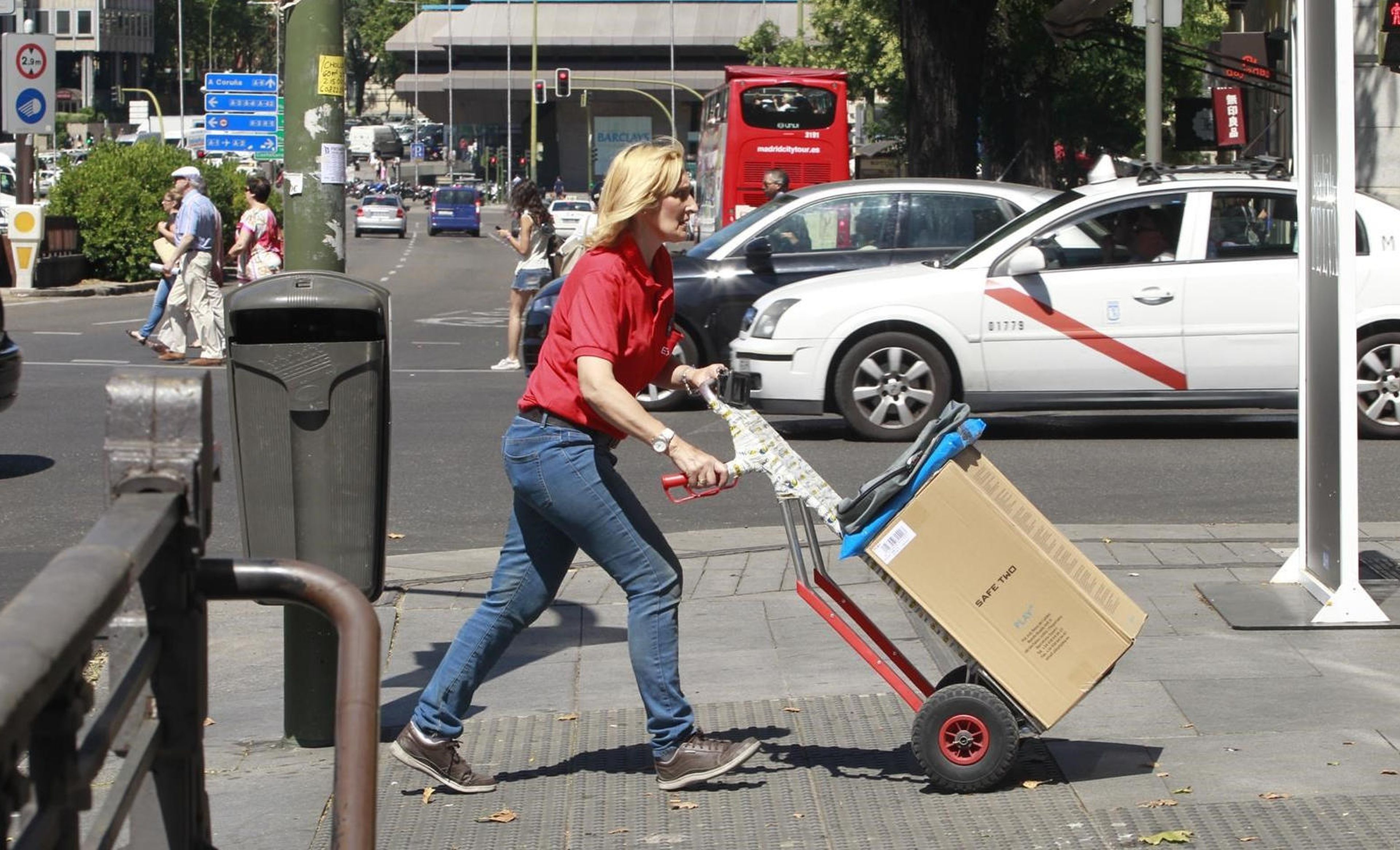 Mujer trabajando llevando un paquete en la calle