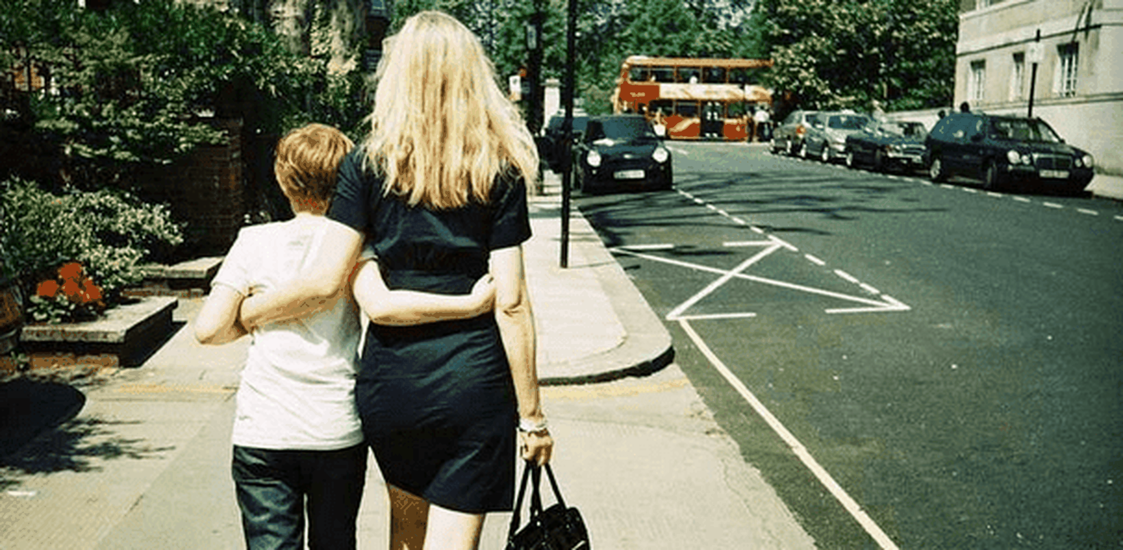 niño camina junto a su madre por la calle