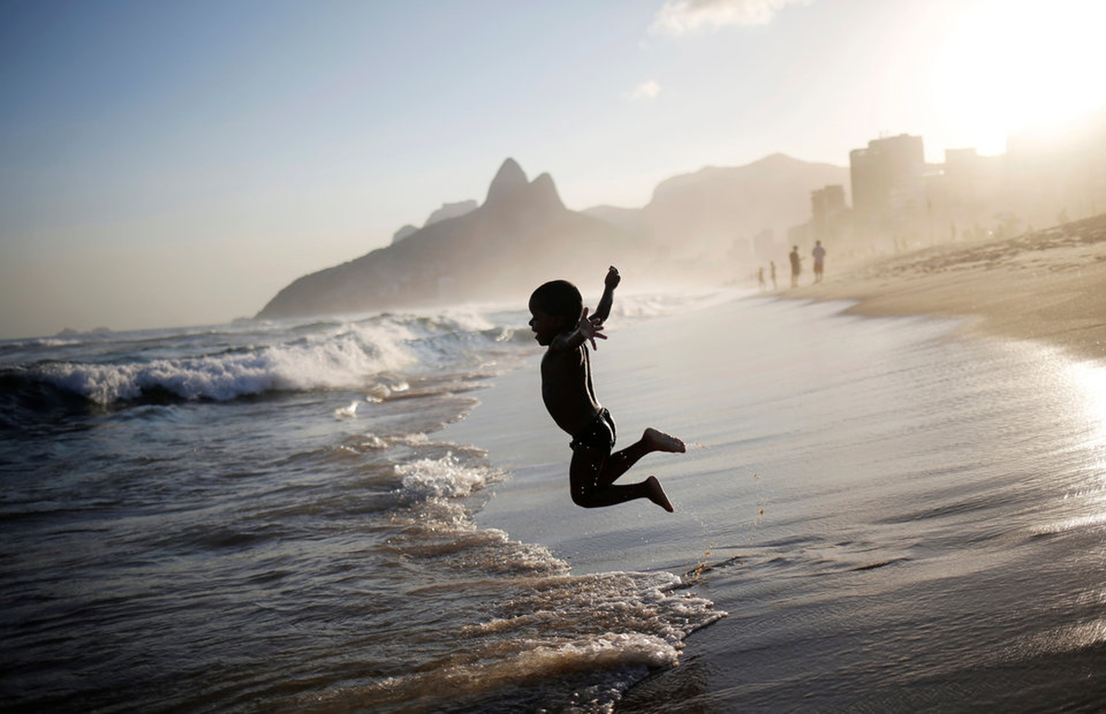 Niño saltando en la playa en Brasil