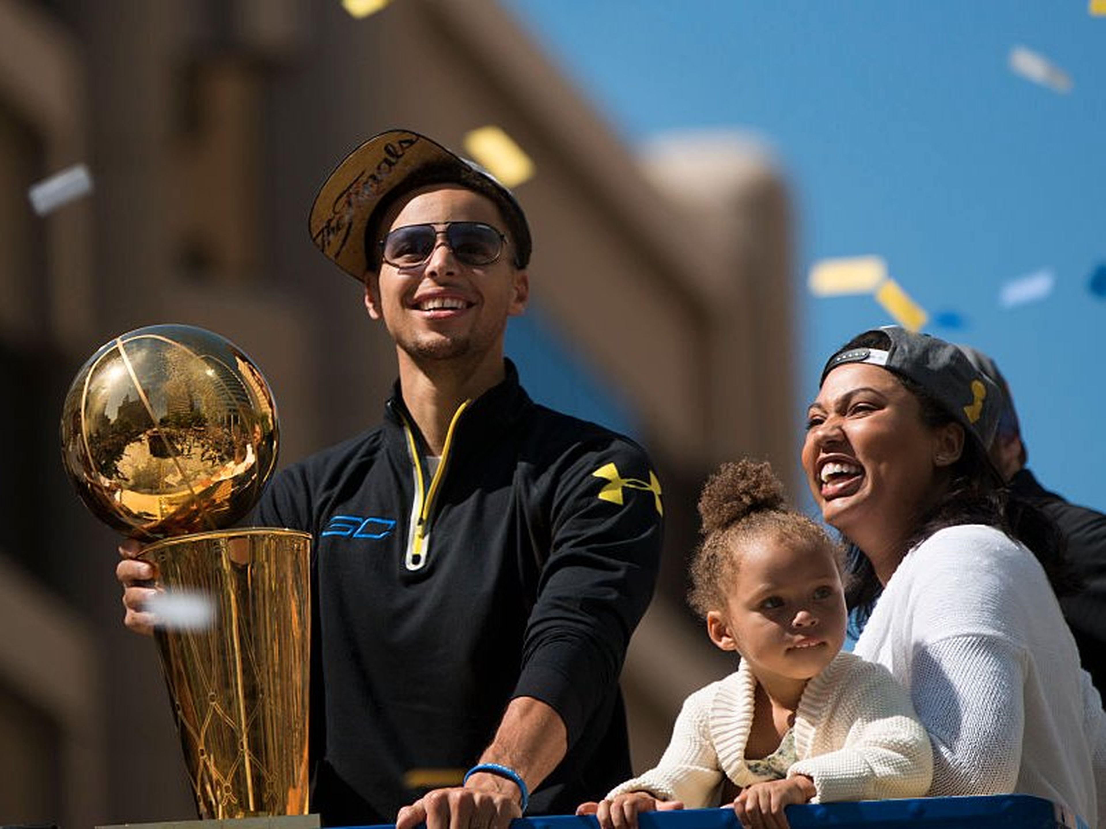 Stephen Curry con su hija Riley y su mujer, Ayesha, durante la cabalgata de celebración de los Golden State Warriors en Oakland (California).