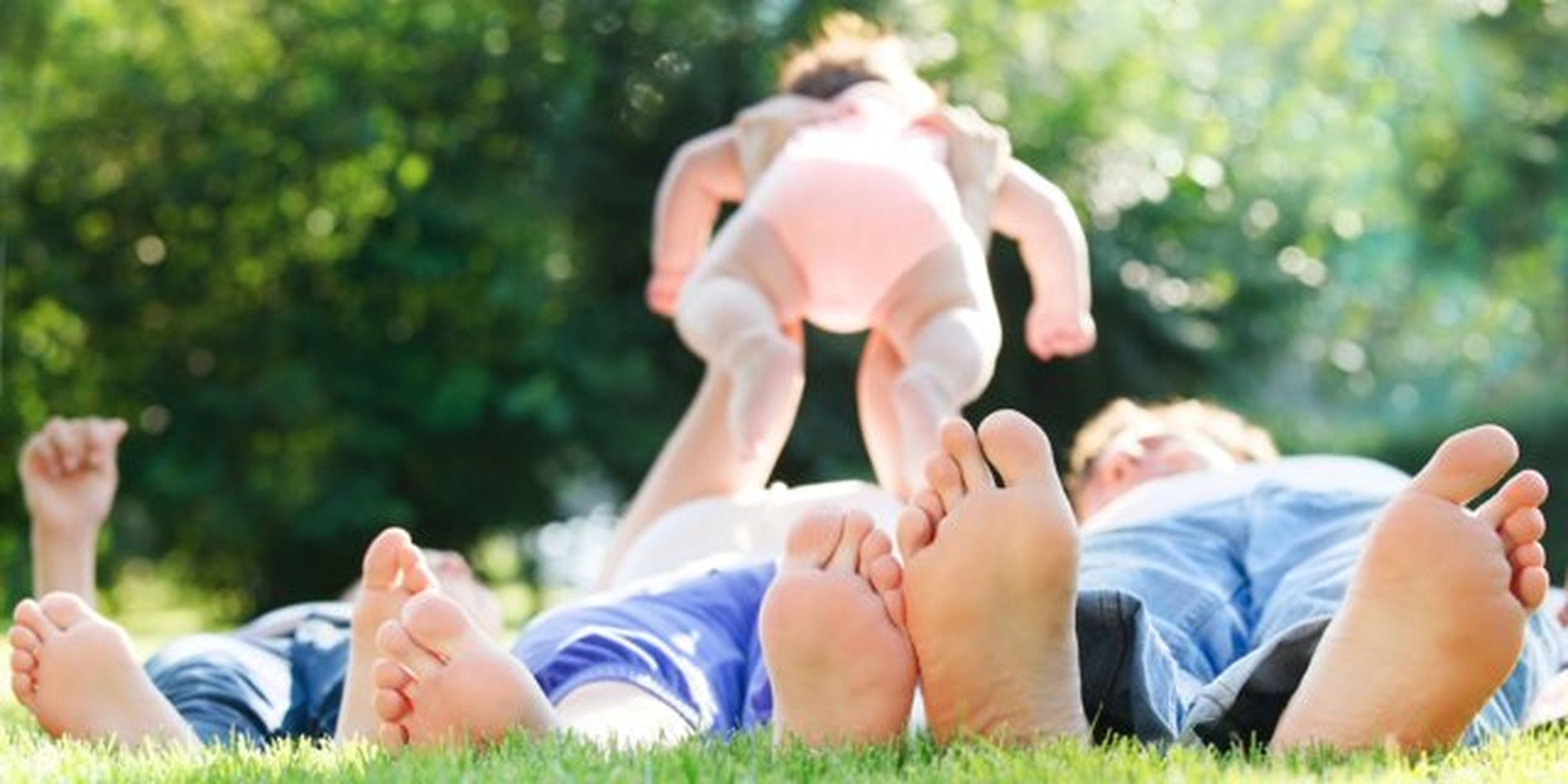 padres jugando con su bebe en el parque
