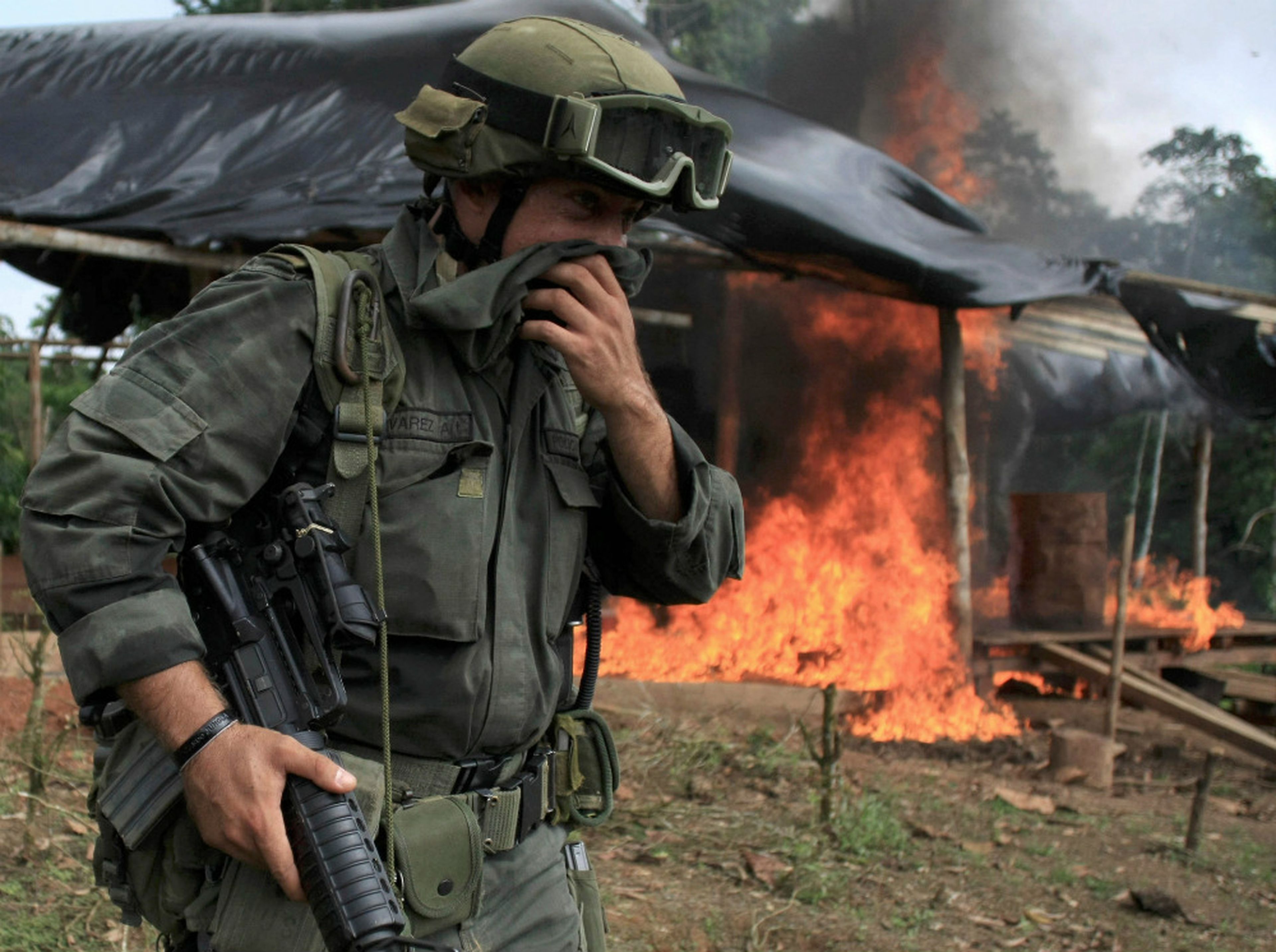 Un miembro de una brigada antinarcóticos frente a una cabaña en llamas durante una redada para destruir un laboratorio de coca cerca de Tumaco, región situada en el sur de Colombia, el 8 de junio de 2008.