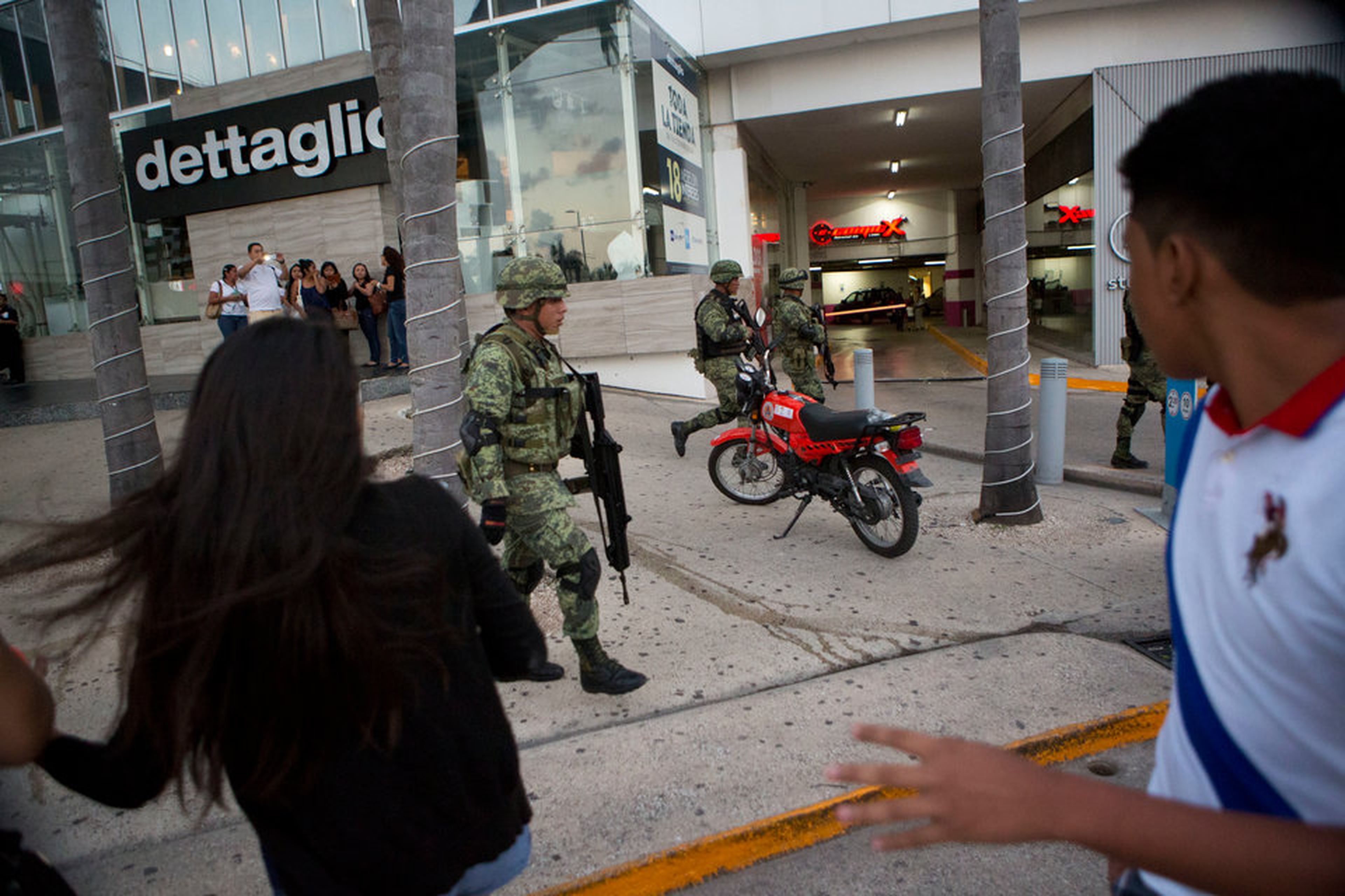 La gente reacciona con ansia a las patrullas de soldados dentro del centro comercial de la Plaza de las Américas, en Cancún.