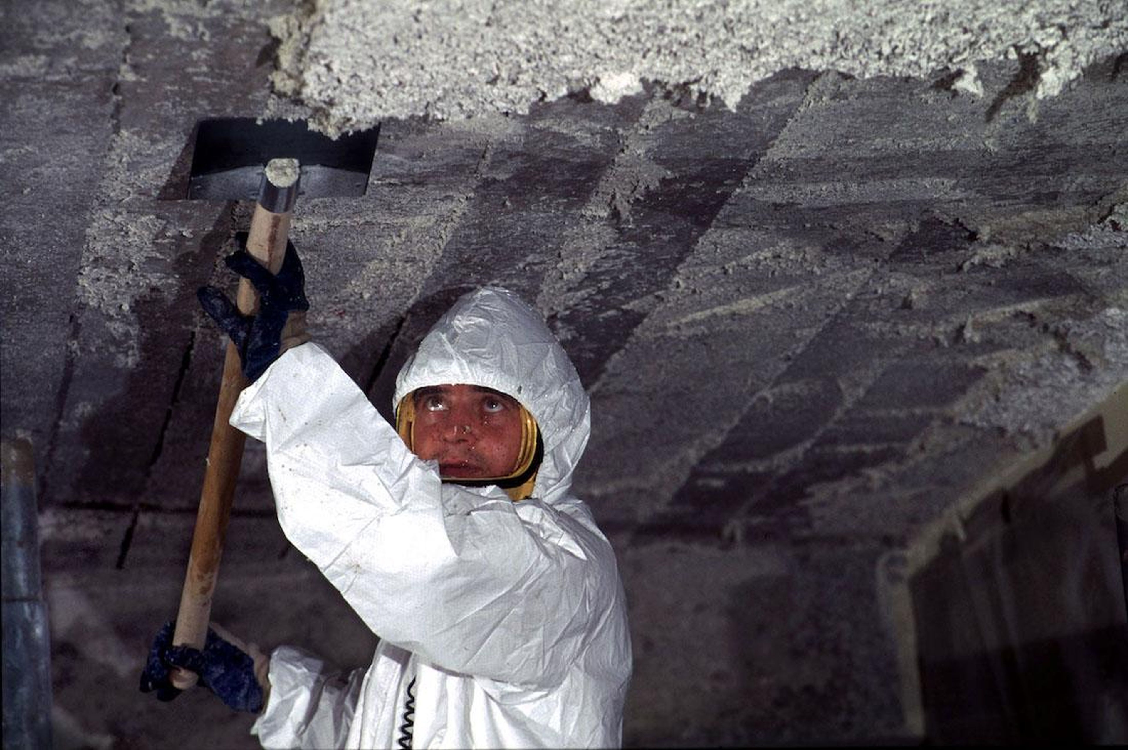 A worker removes asbestos cement from the ceiling of a primary school in France.