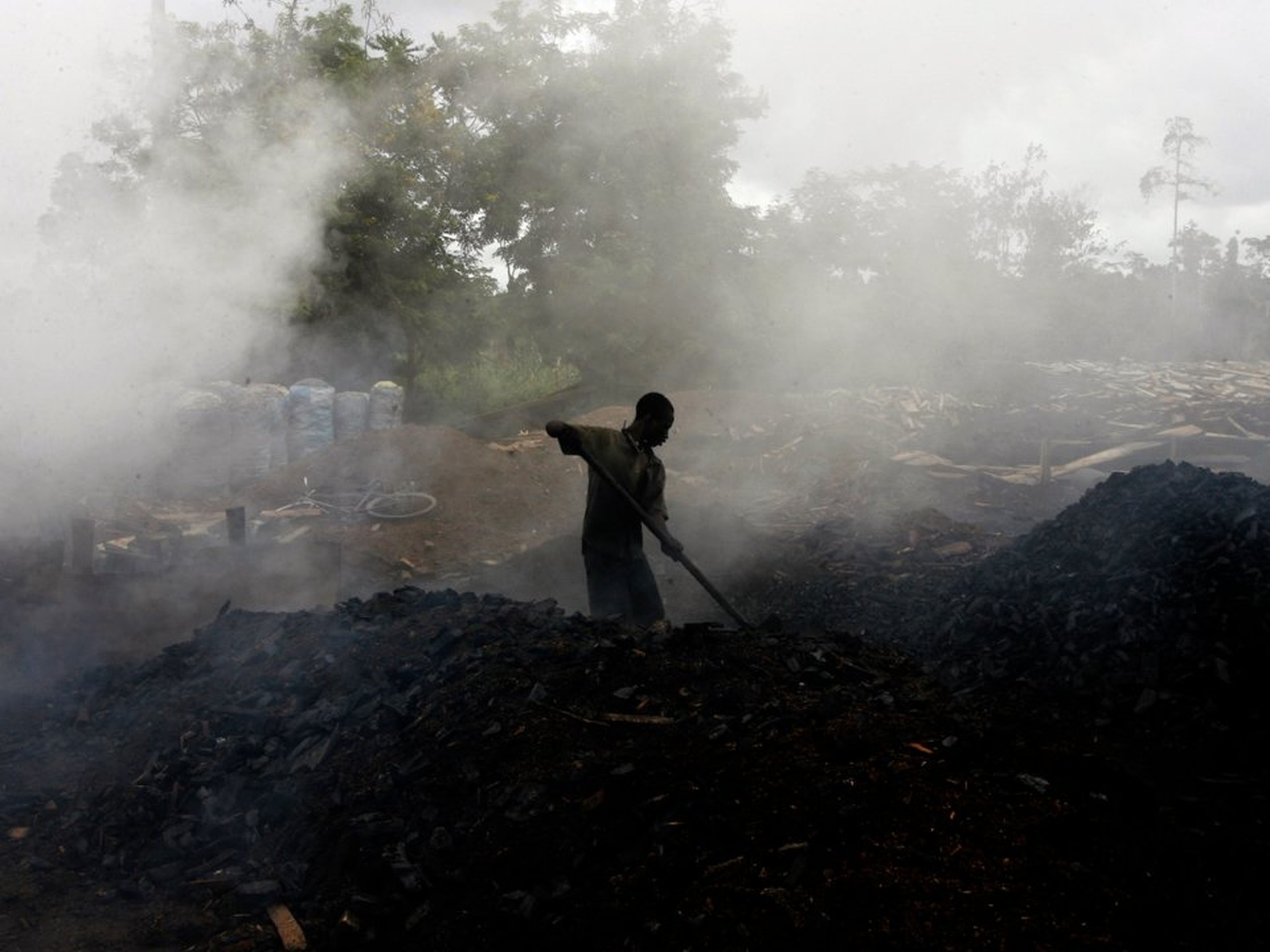 Un hombre trabaja en una fábrica tradicional de carbón en Duekoue, oeste de Costa de Marfil.