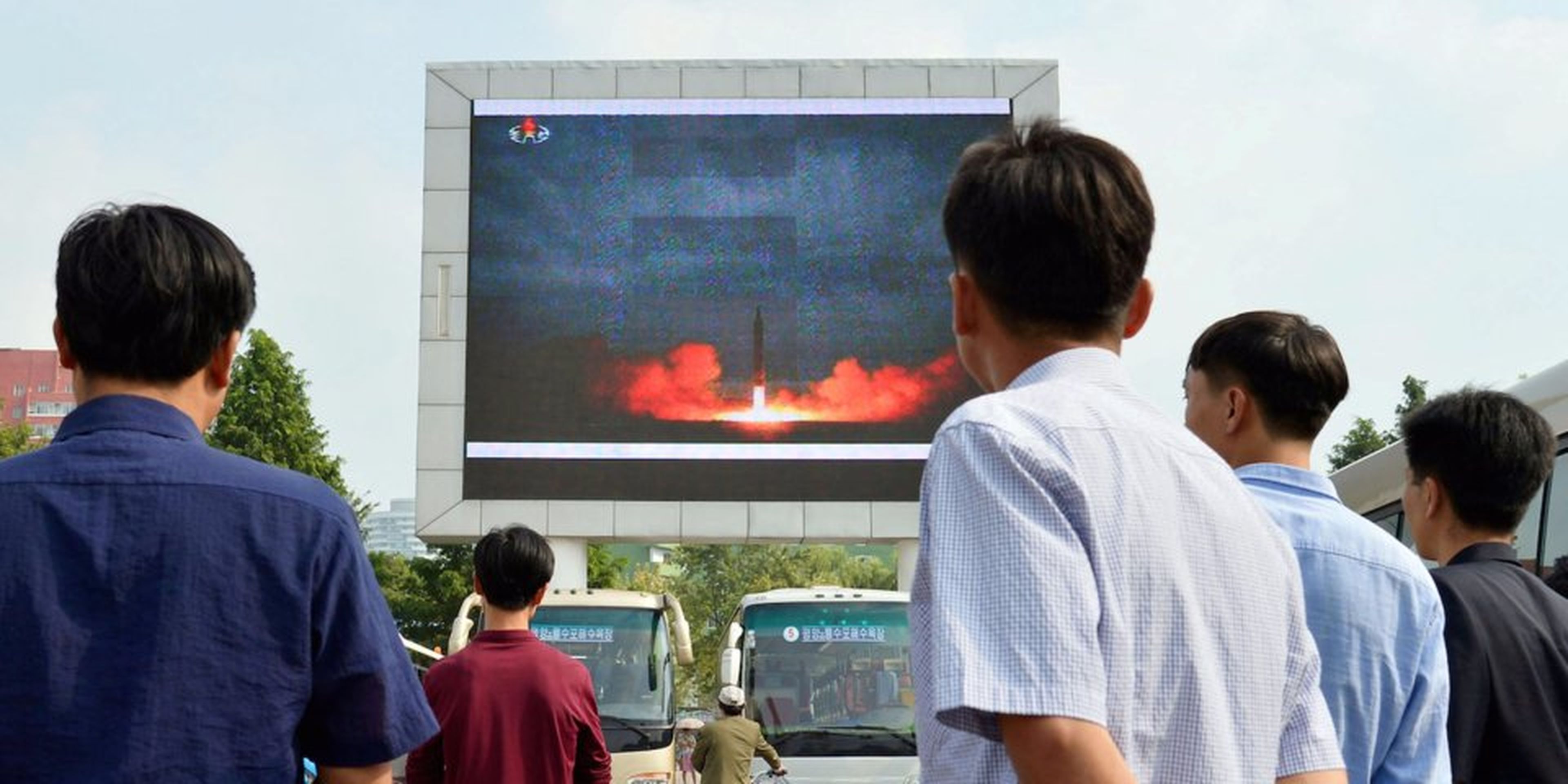 Los norcoreanos ven el lanzamiento de misiles balísticos de alcance intermedio Hwasong-12 de Corea del Norte en agosto de 2017
