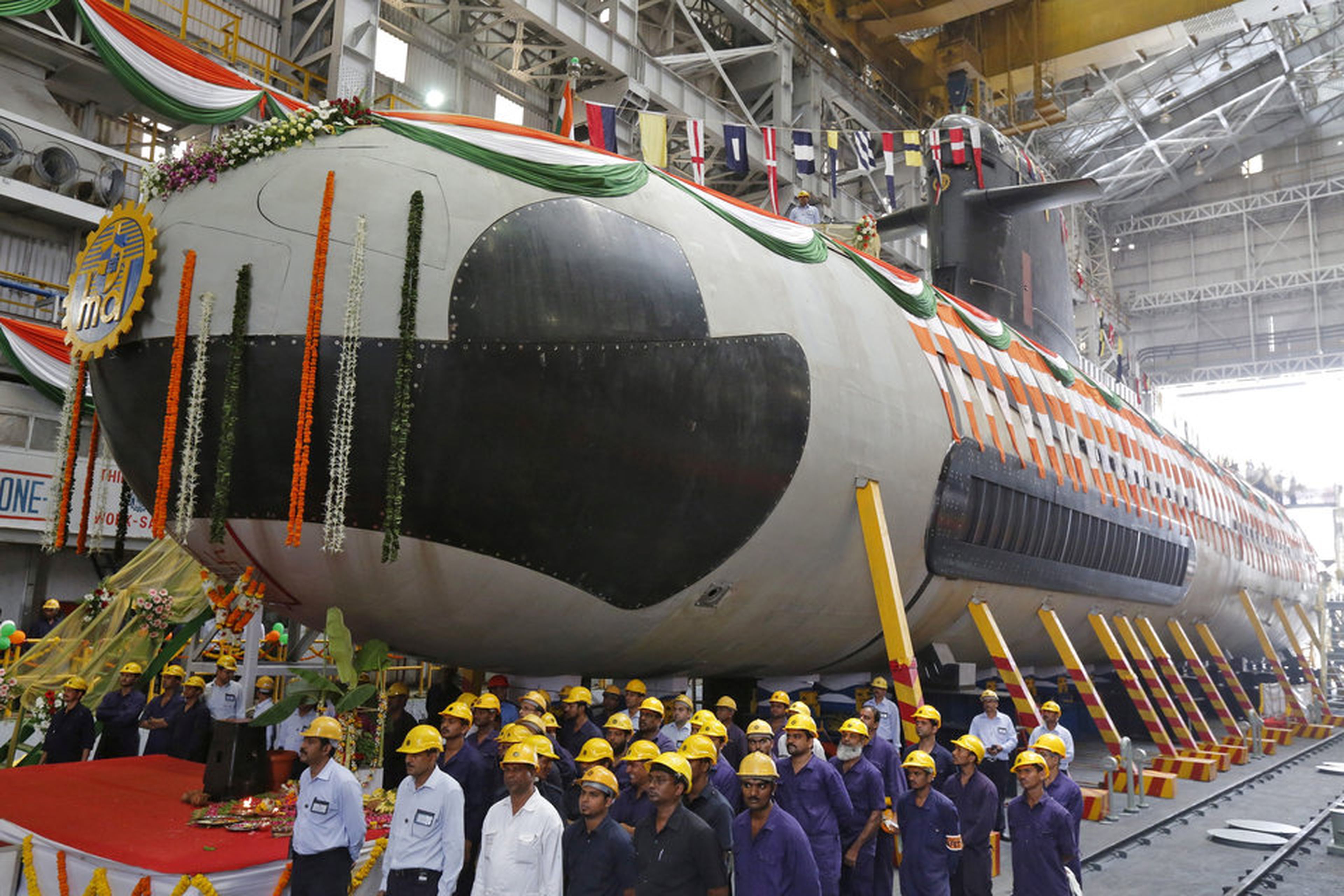 Trabajadores forman delante del primer submarino del ejército indio.