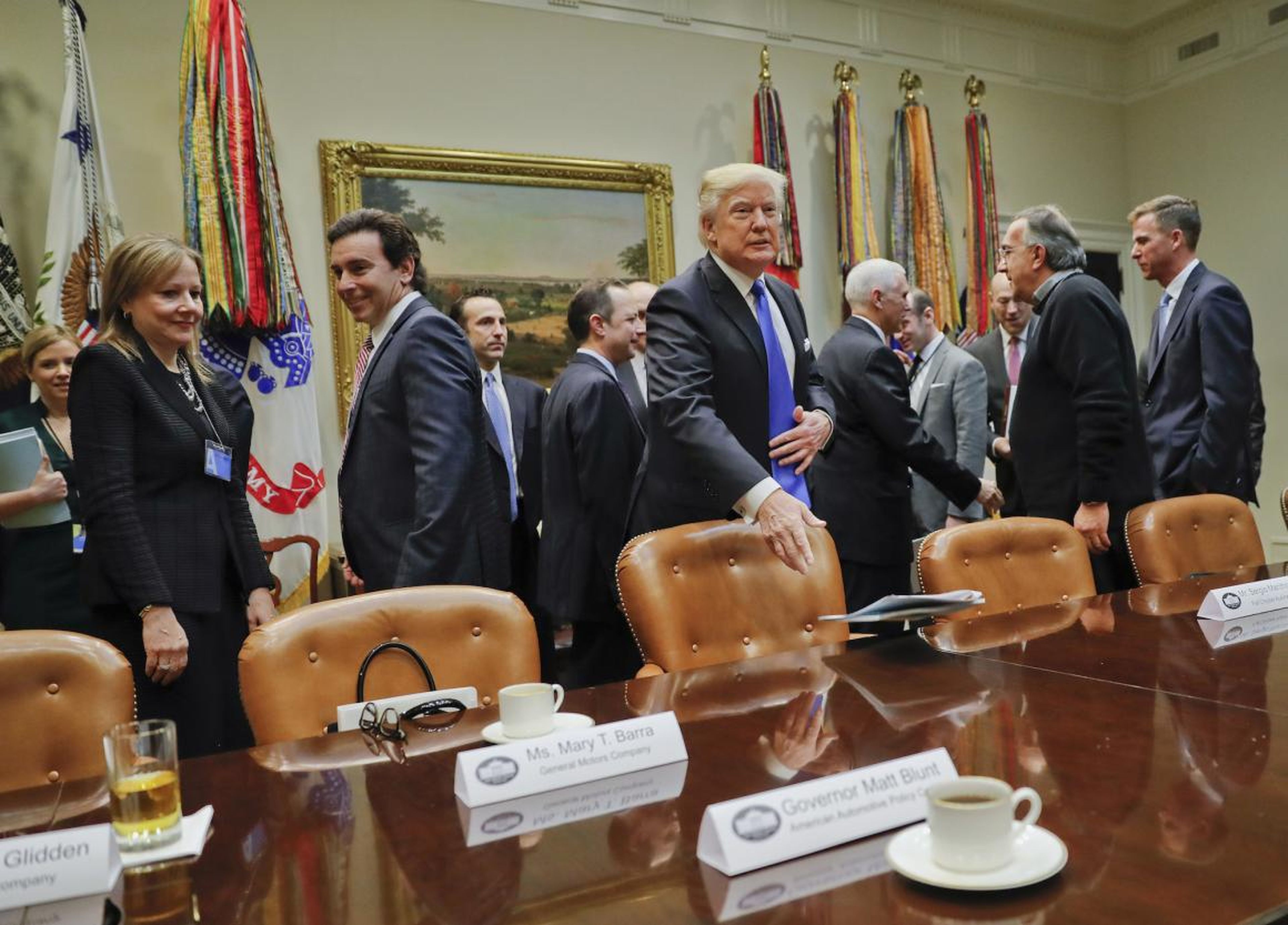El presidente Donald Trump arroja su carpeta sobre la mesa antes del comienzo de una reunión con los líderes del automóvil.