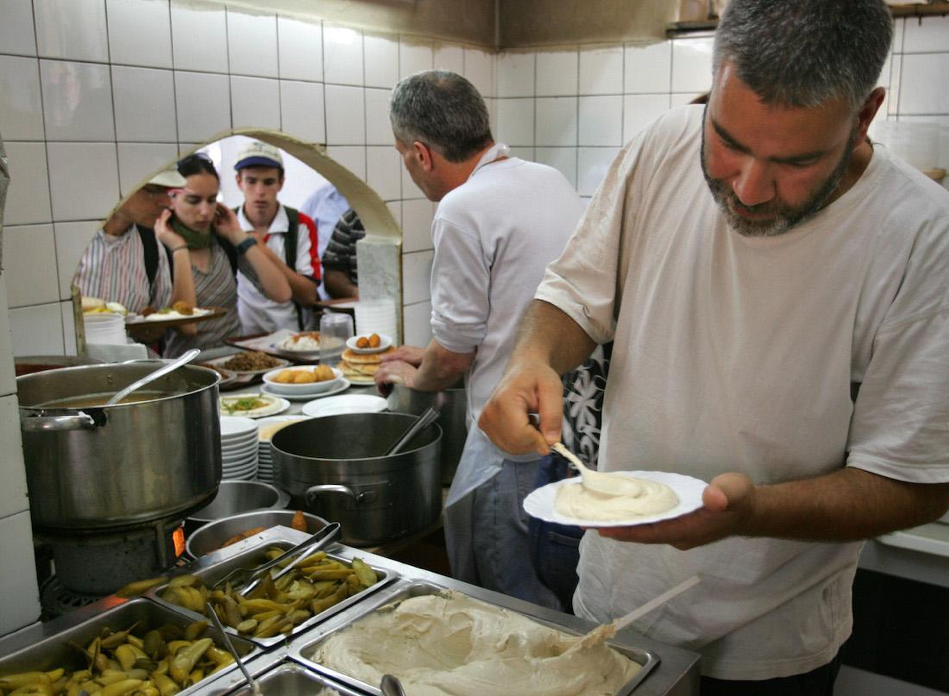 Shmulik Nahmias prepares to serve a plate at Rahmo, his legendary hummus restaurant in Jerusalem's Mahane Yehuda market.