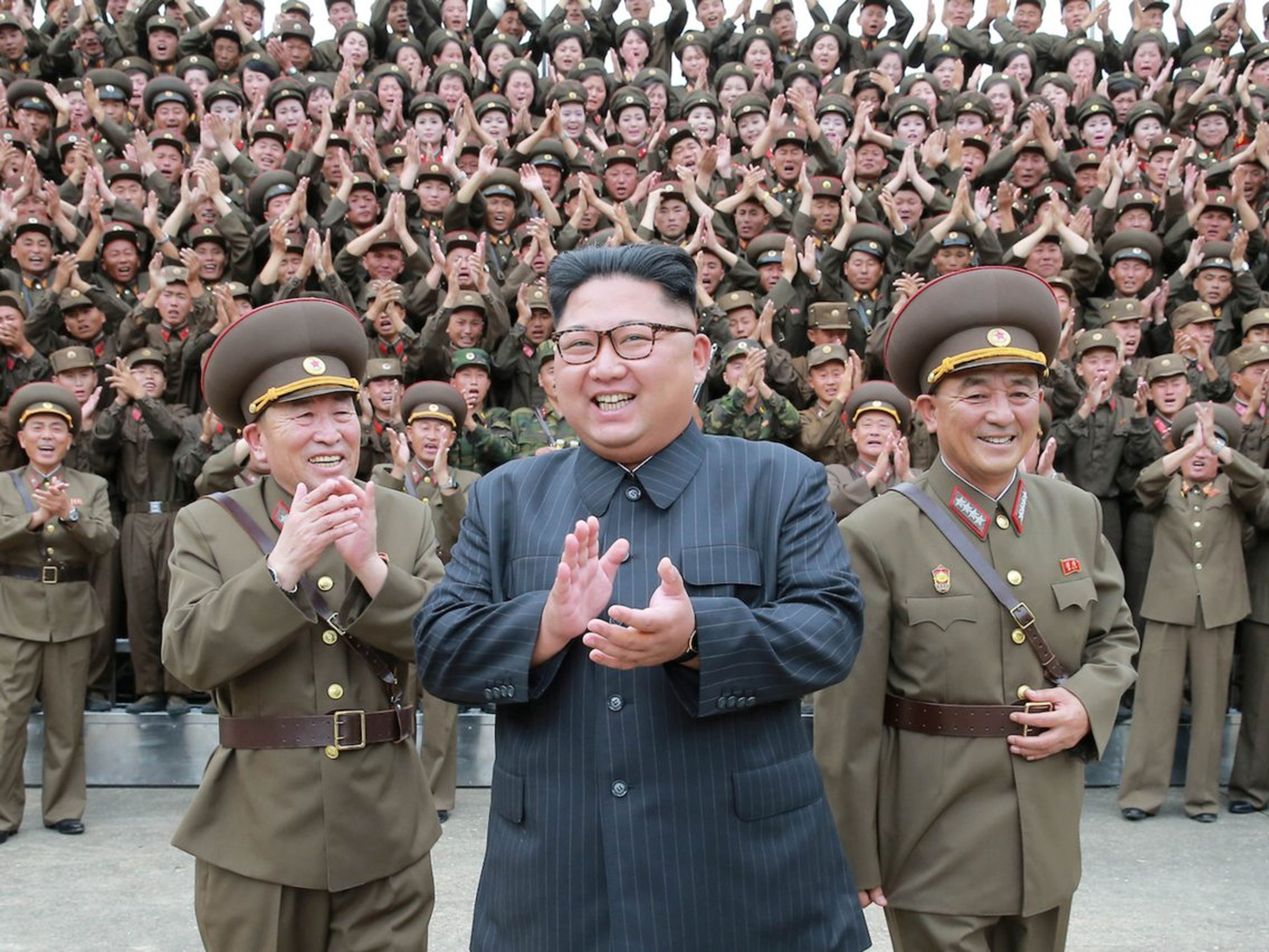 El líder norcoreano Kim Jong Un aplaude con oficiales militares en el Comando de la Fuerza Estratégica del Ejército Popular de Corea.