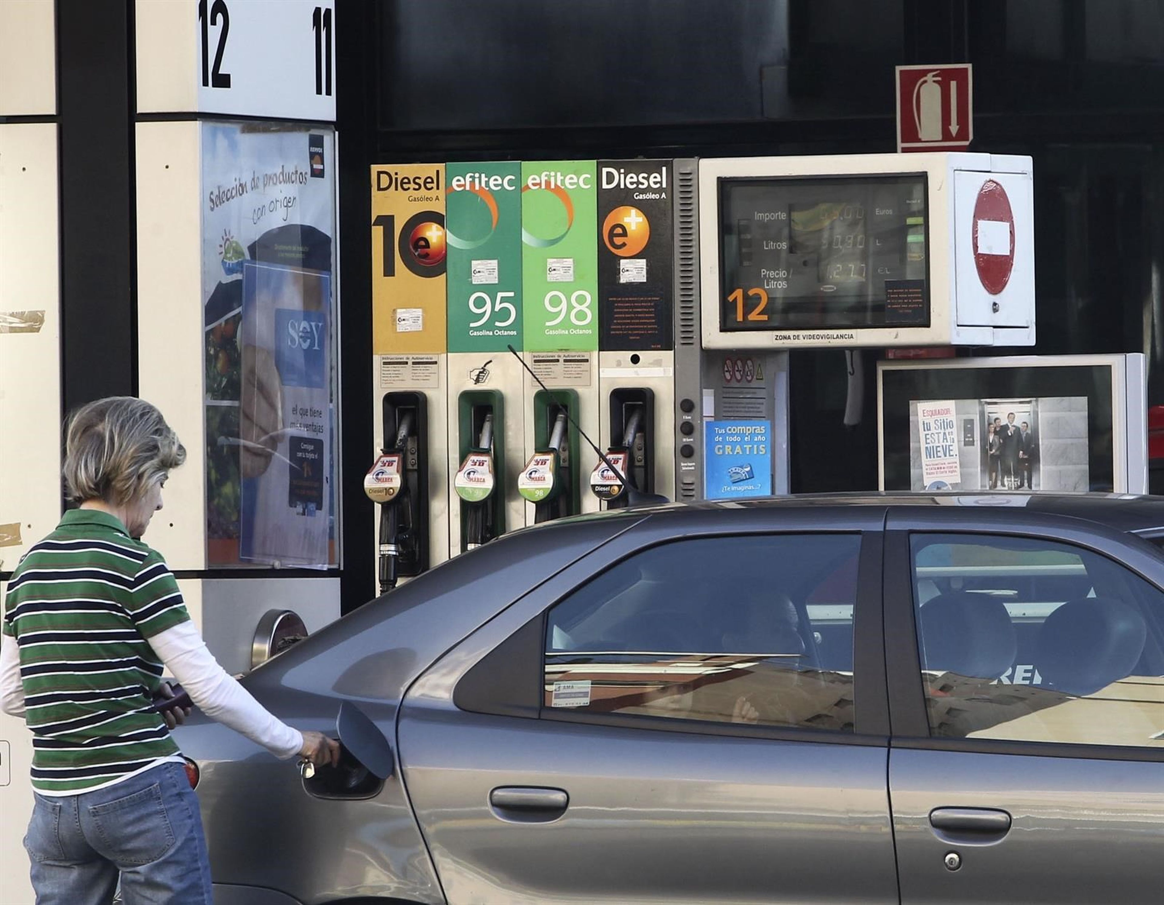 Una mujer repostando su coche en una gasolinera