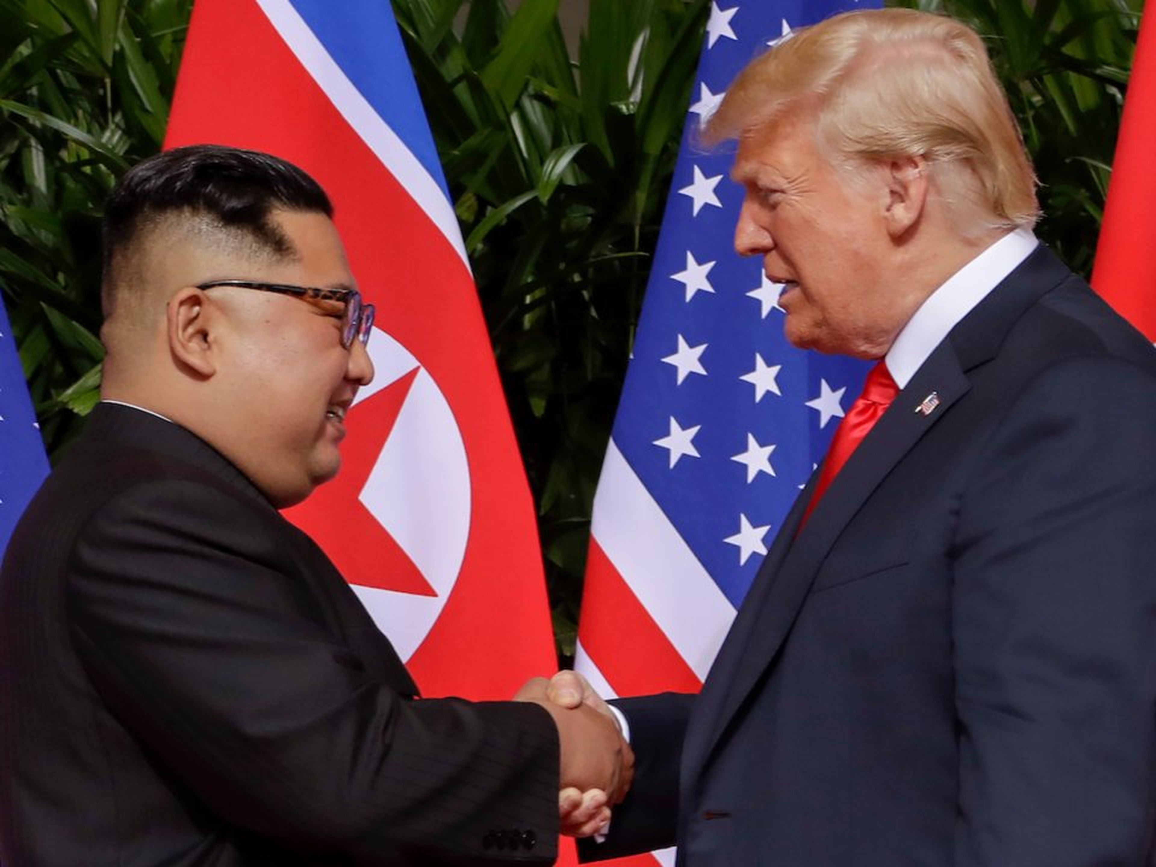El presidente Donald Trump estrecha la mano del líder norcoreano Kim Jong Un en el complejo Capella en la isla Sentosa, el 12 de junio de 2018 en Singapur.