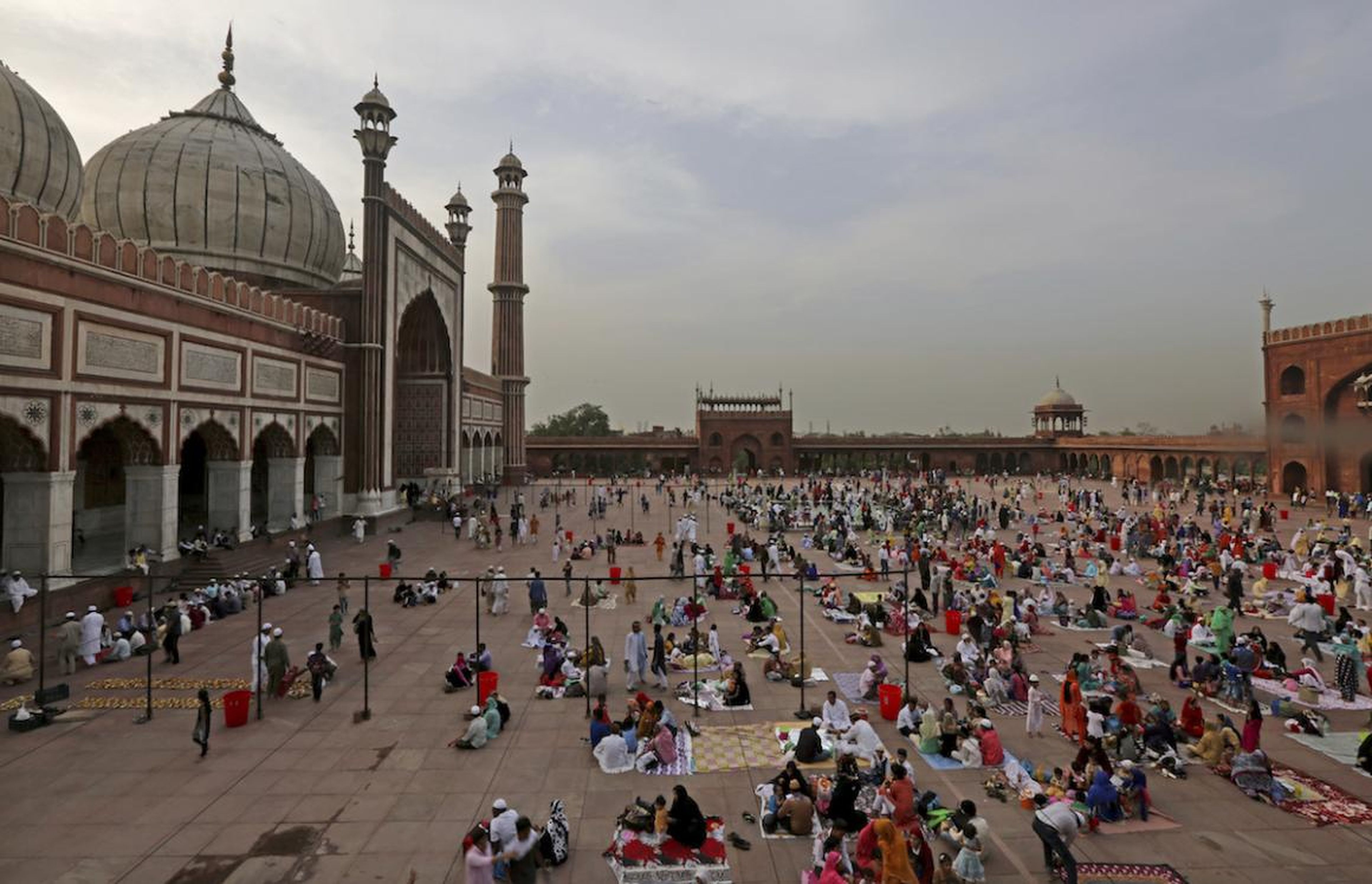 Indian Muslim families gather in the compound of Jama Masjid to break their day-long fast in New Delhi, India, Wednesday, June 14, 2017.