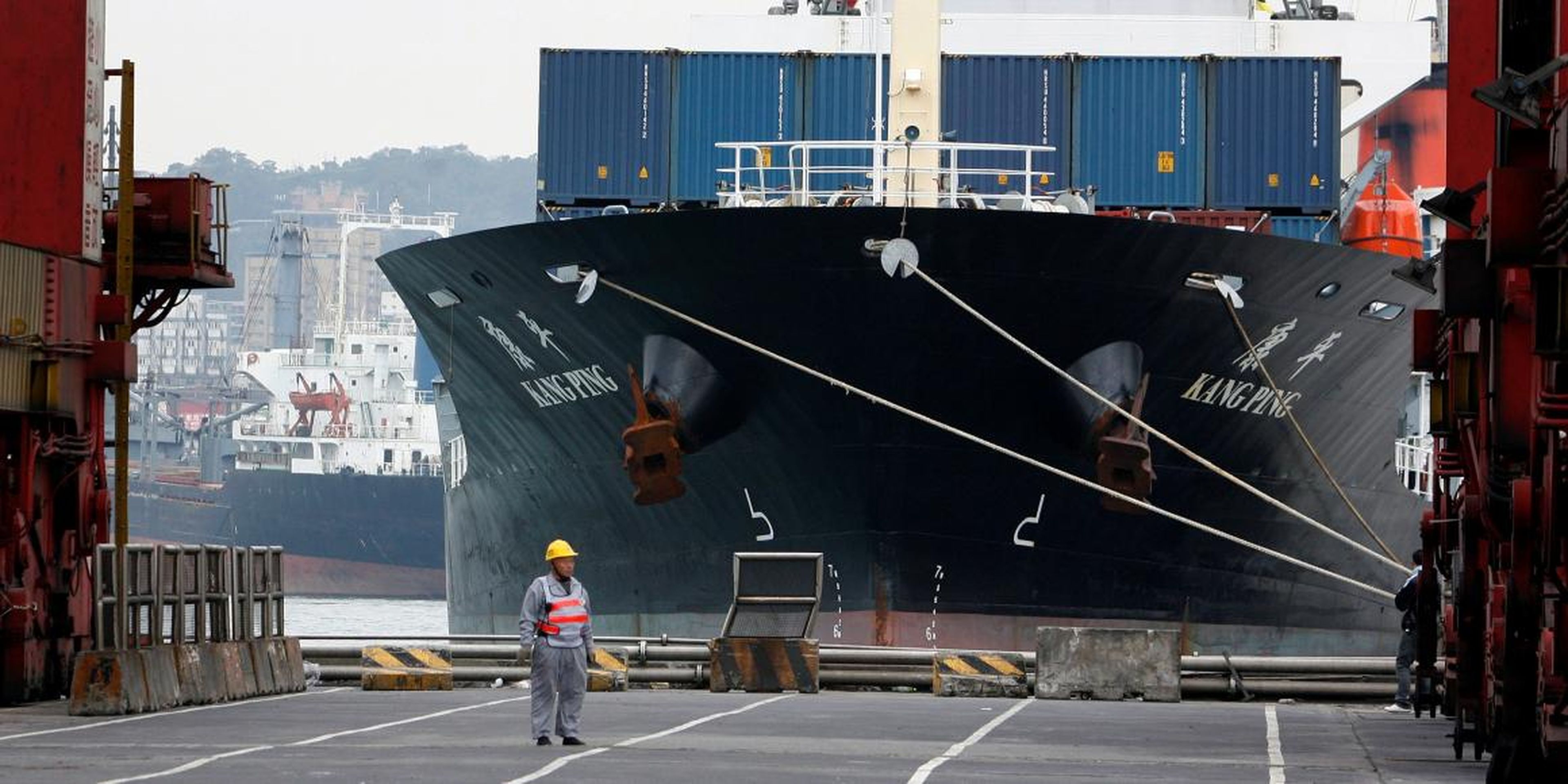 A man stands in front of a cargo ship at a port in the northern Taiwan city of Keelung December 15, 2008.
