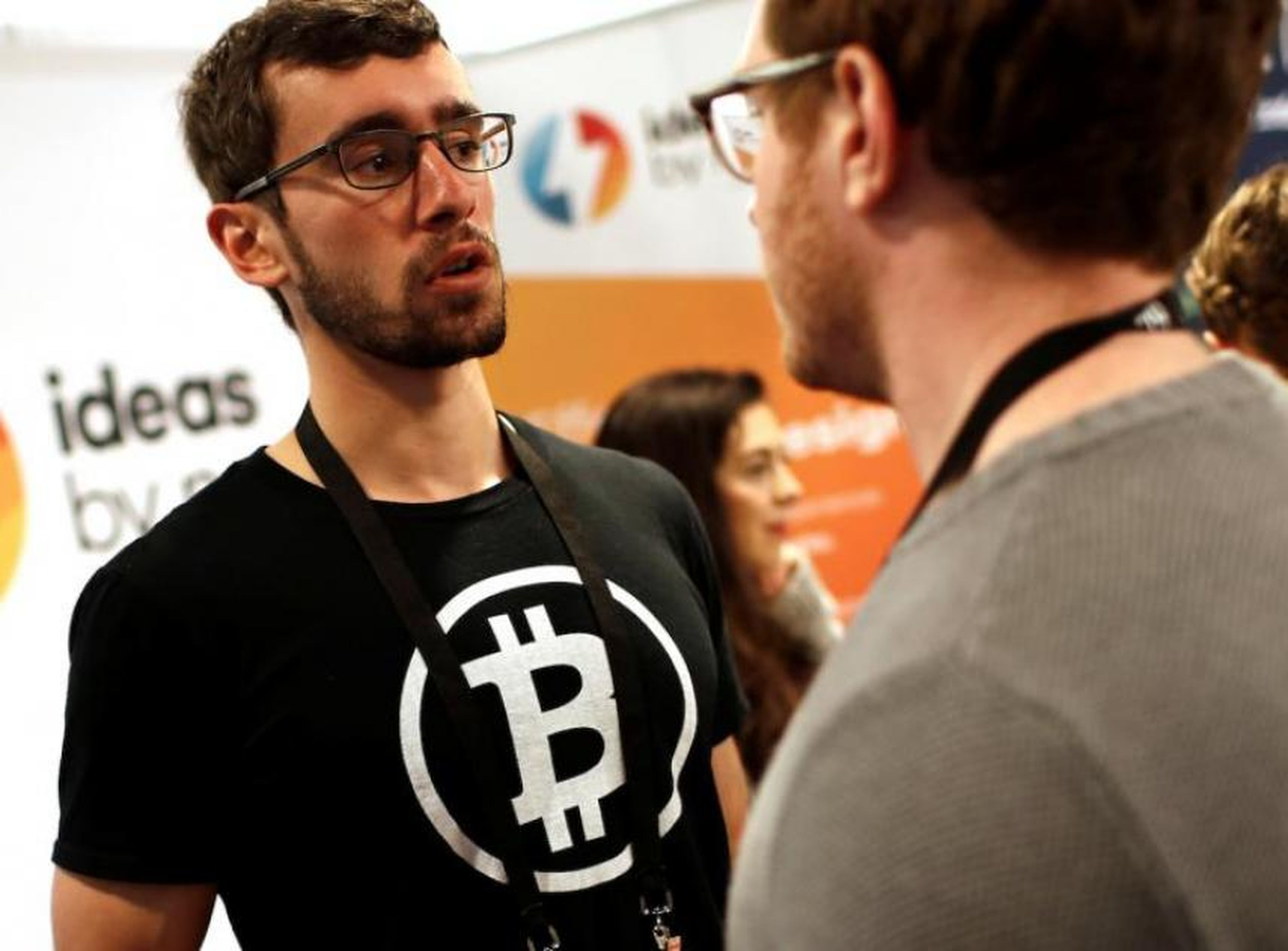 Un hombre lleva una camiseta con el logo de bitcoin en la Conferencia de Nueva York sobre la tecnología blockchain de 2018.