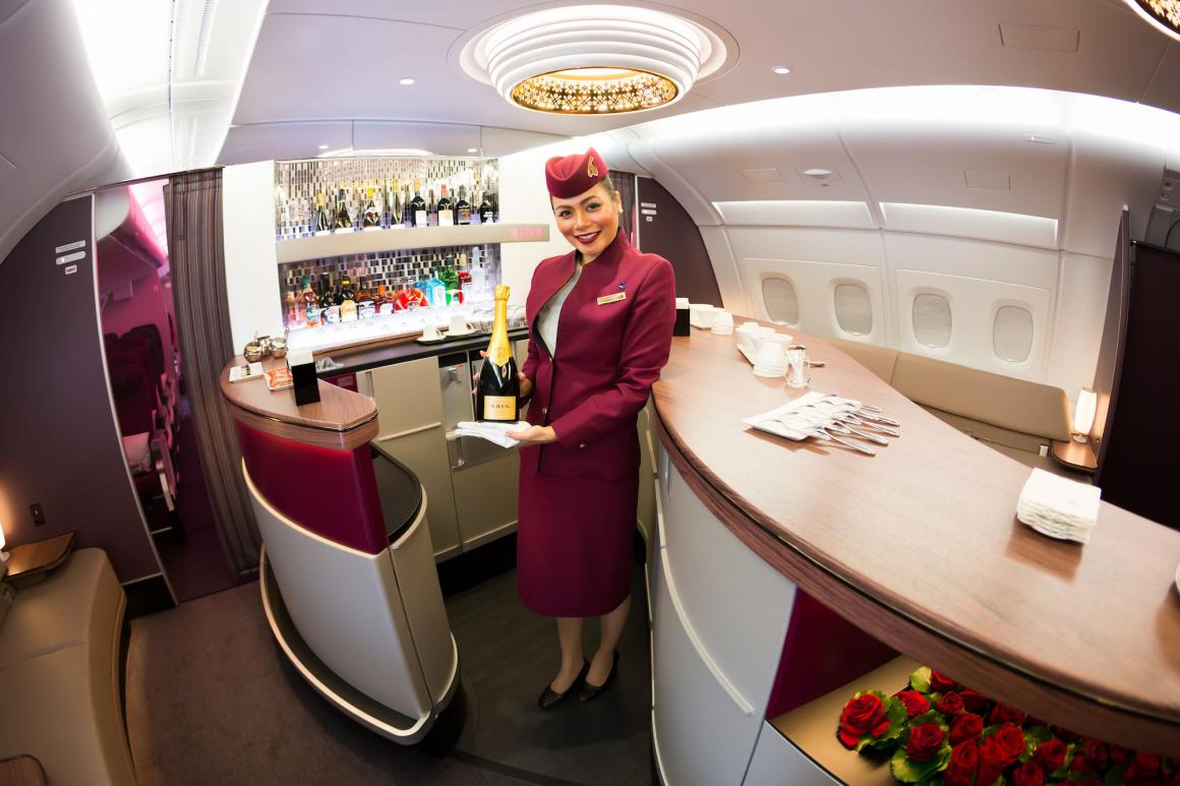 Una azafata te saluda al entrar en un avión de Qatar Airways.