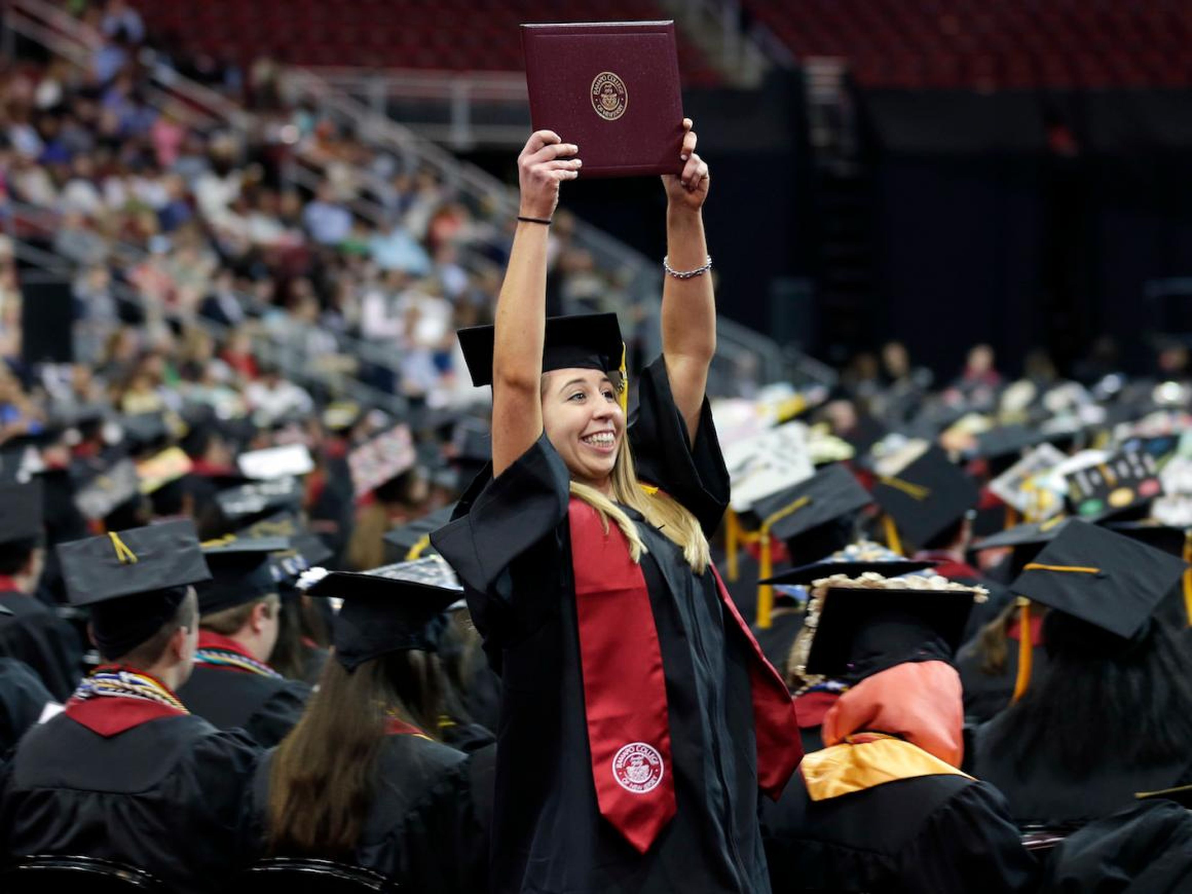 Emma O'Donoghue holds up her diploma as she returns to her seat during an undergraduate commencement ceremony for Ramapo College in Newark, N.J., Thursday, May 10, 2018.