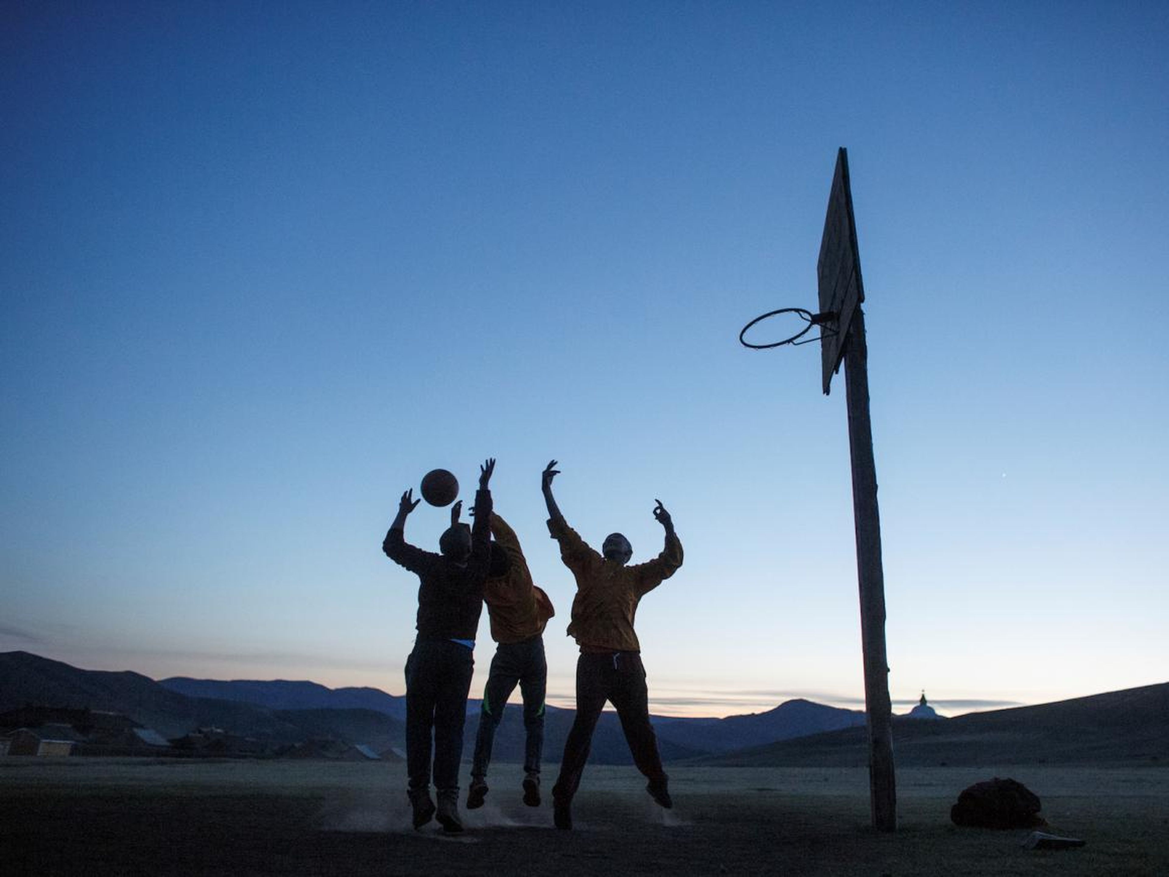 Monks at the monastery wind down by playing basketball at sunset …
