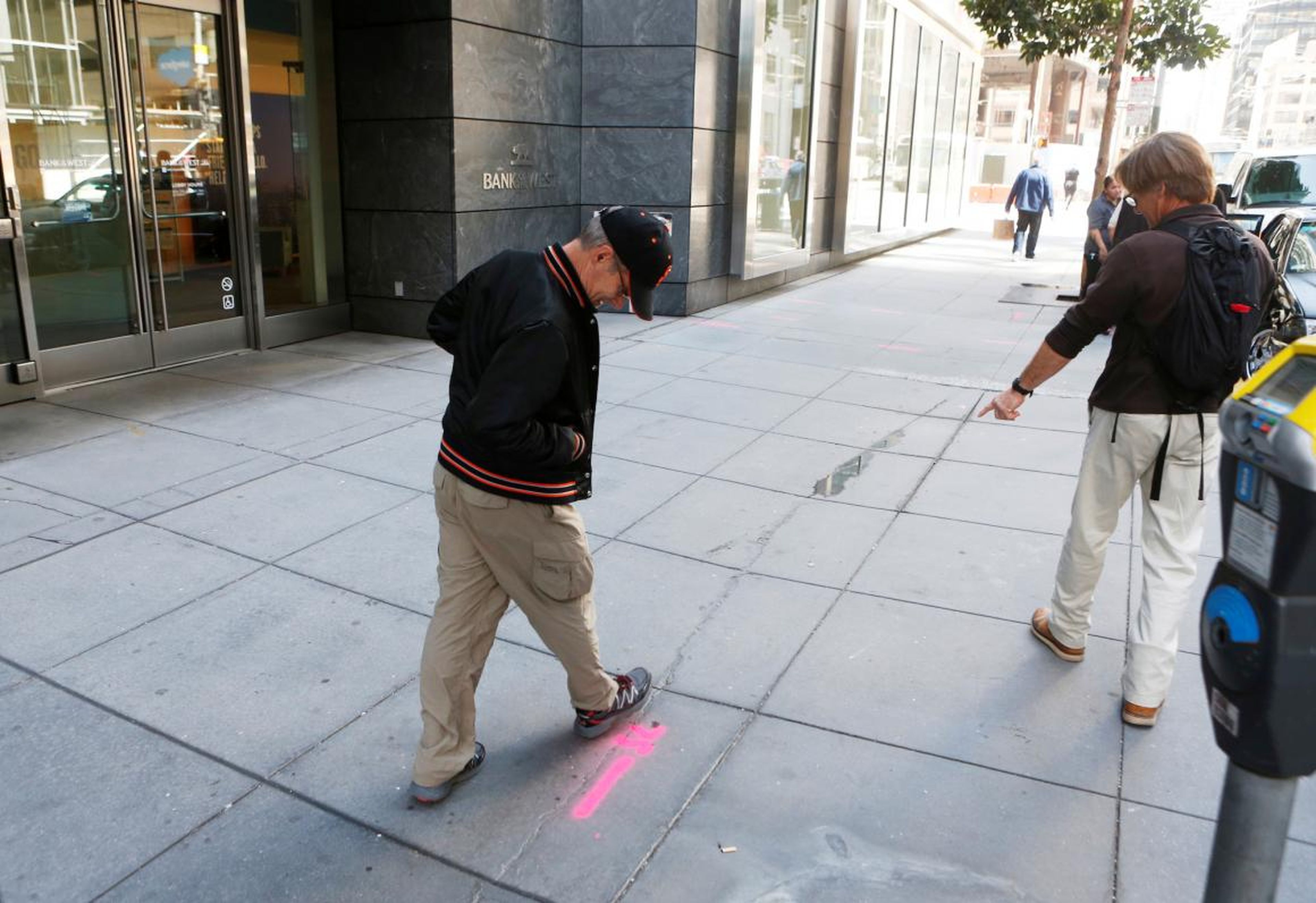 Pedestrians inspect cracks near the sinking Millennium Tower in San Francisco, California.