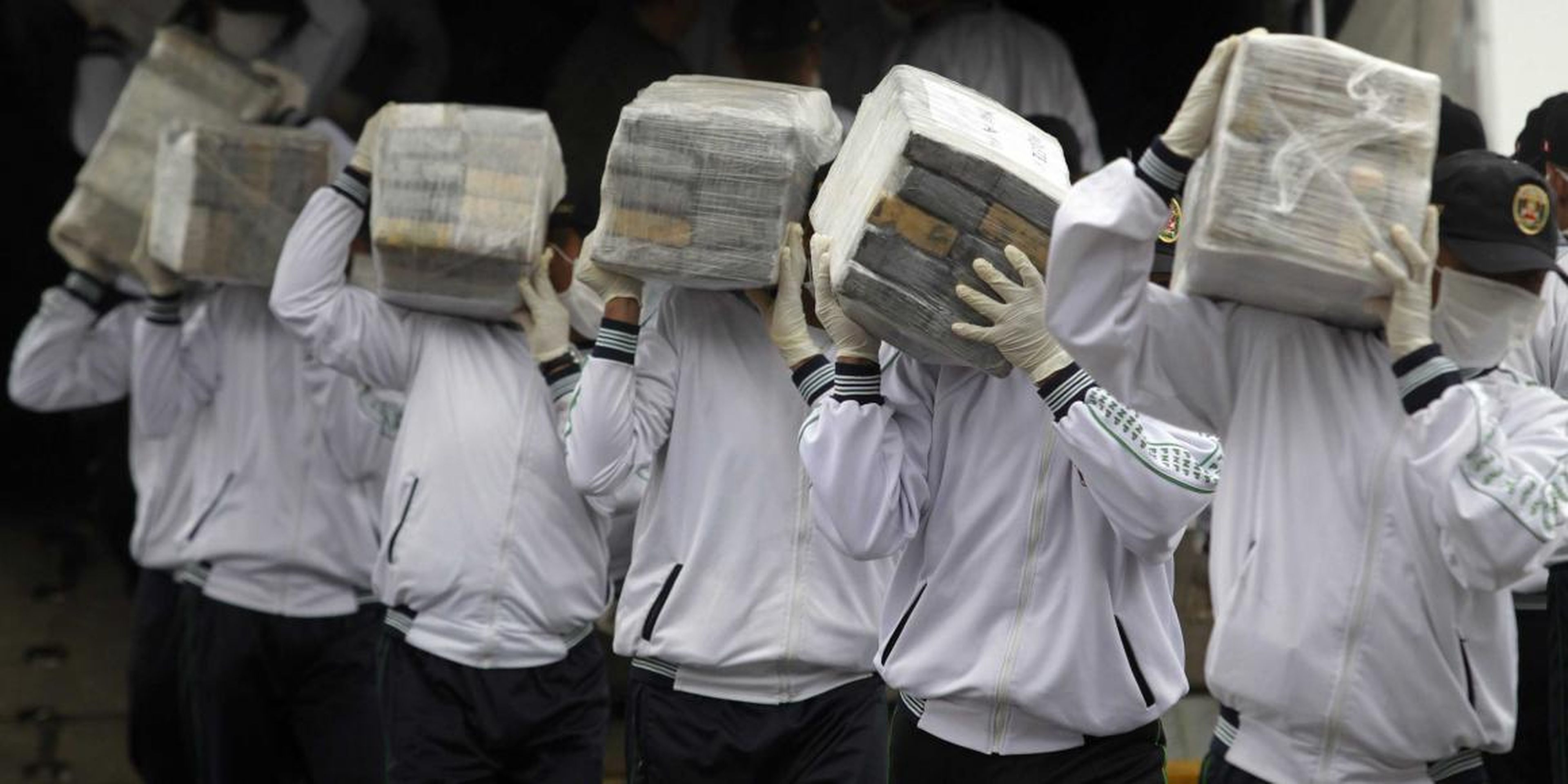 Police officers carry seized cocaine in Lima, Peru, in 2014. A large amount of Peruvian cocaine flowed through China between 2011 and 2015.