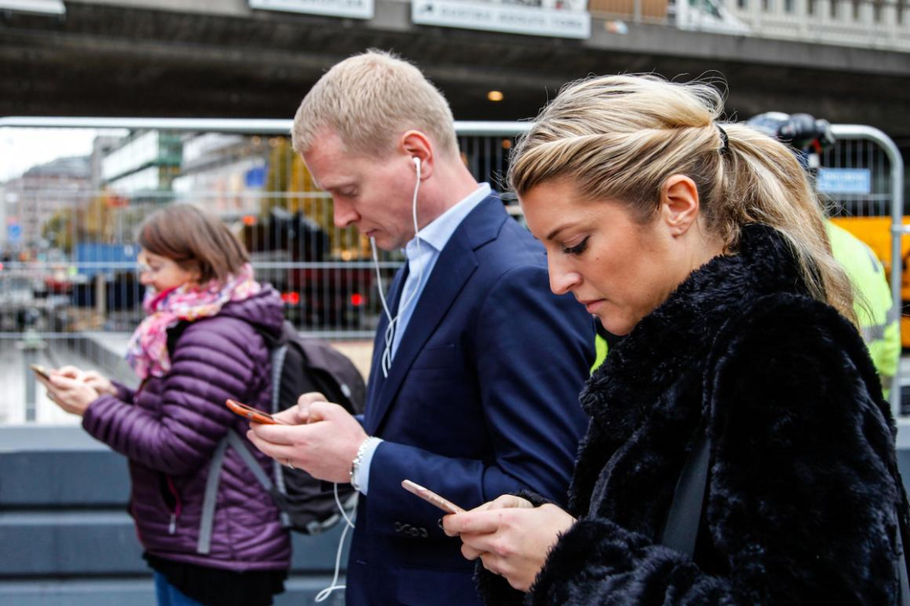 Viajeros mirando sus móviles en Estocolmo, Suecia.