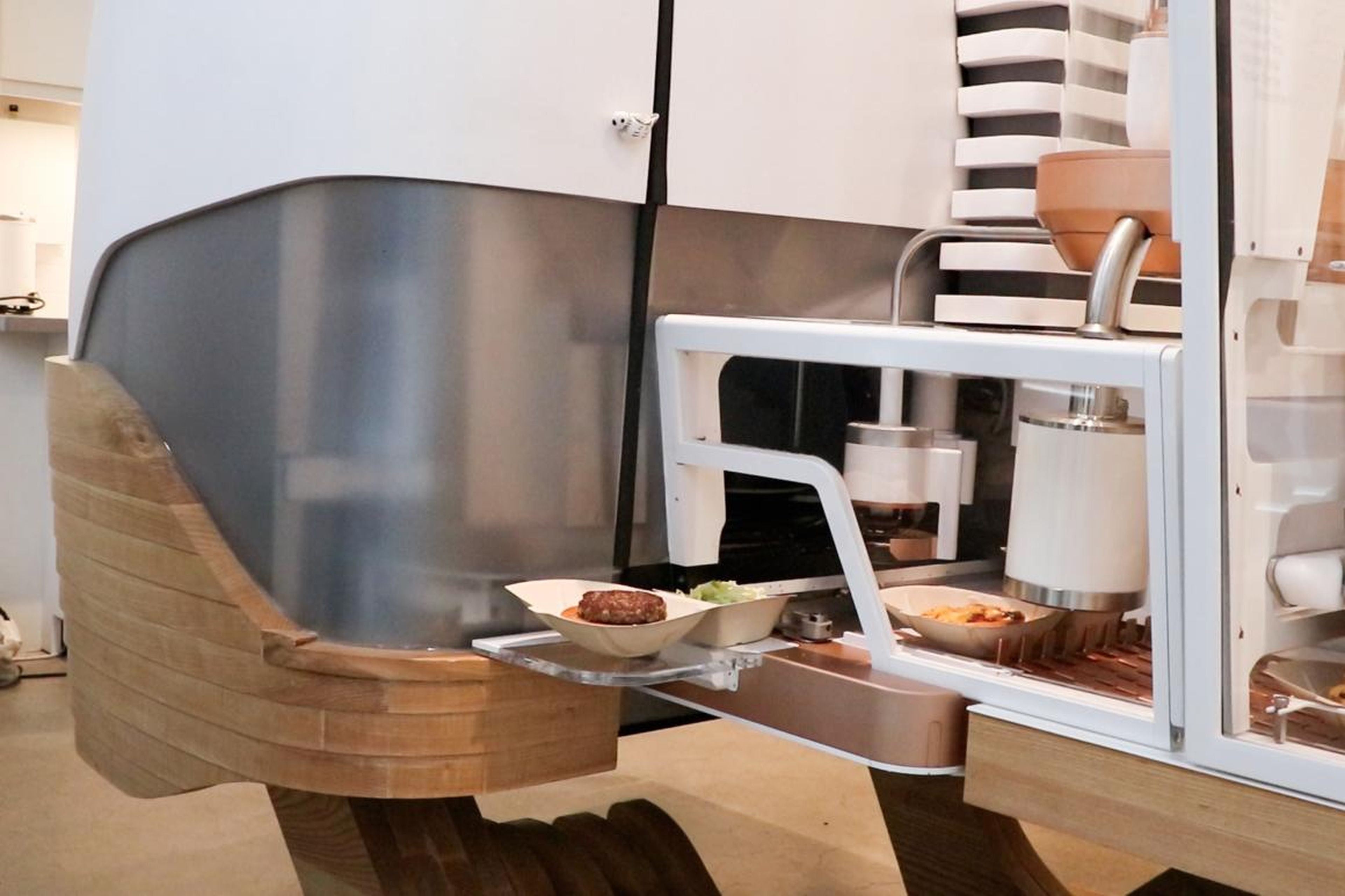 While the bun gets all the fixings, the robot grinds the meat to order. It takes place in this opaque case, so guests don't see the magic happen.