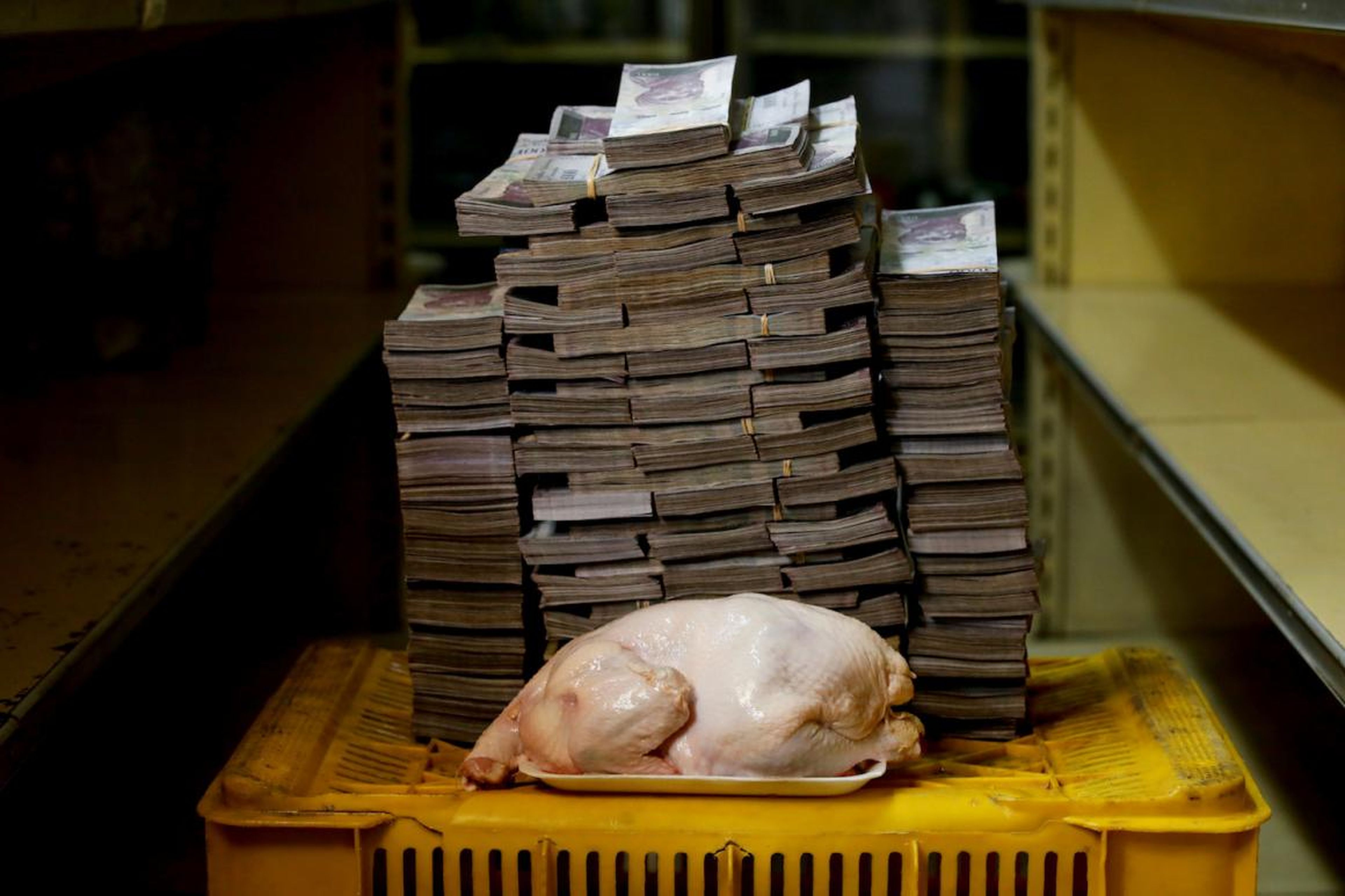 A 2.4 kg chicken is pictured next to 14,600,000 bolivars, its price and the equivalent of 2.22 USD, at a mini-market in Caracas, Venezuela.