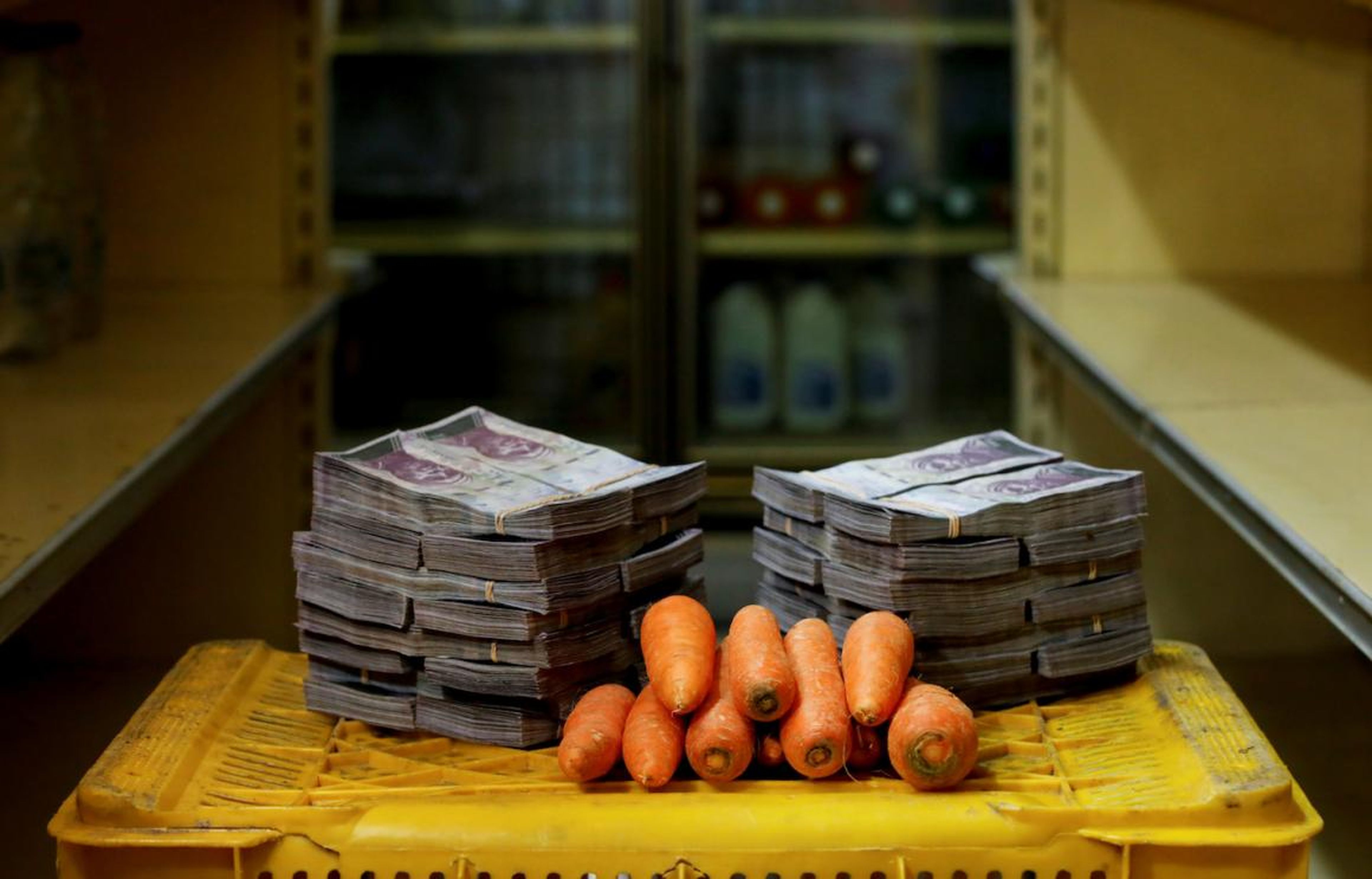 A kilogram of carrots is pictured next to 3,000,000 bolivars, its price and the equivalent of 0.46 USD, at a mini-market in Caracas, Venezuela.