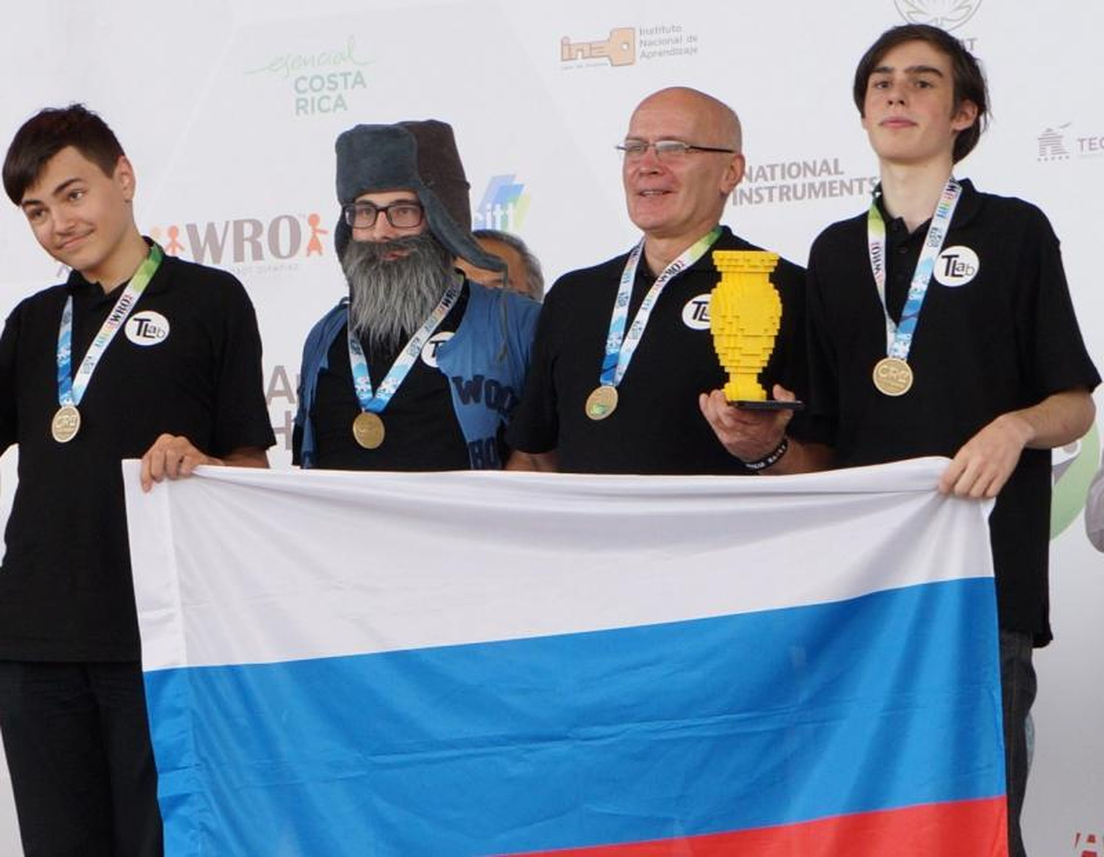 Left to right: Maksim Mikhailov and his team: Daniil Nechaev, Igor Lositsky and Gleb Zagarskikh, as they accept the gold medal at the 2017 World Robot Olympiad.