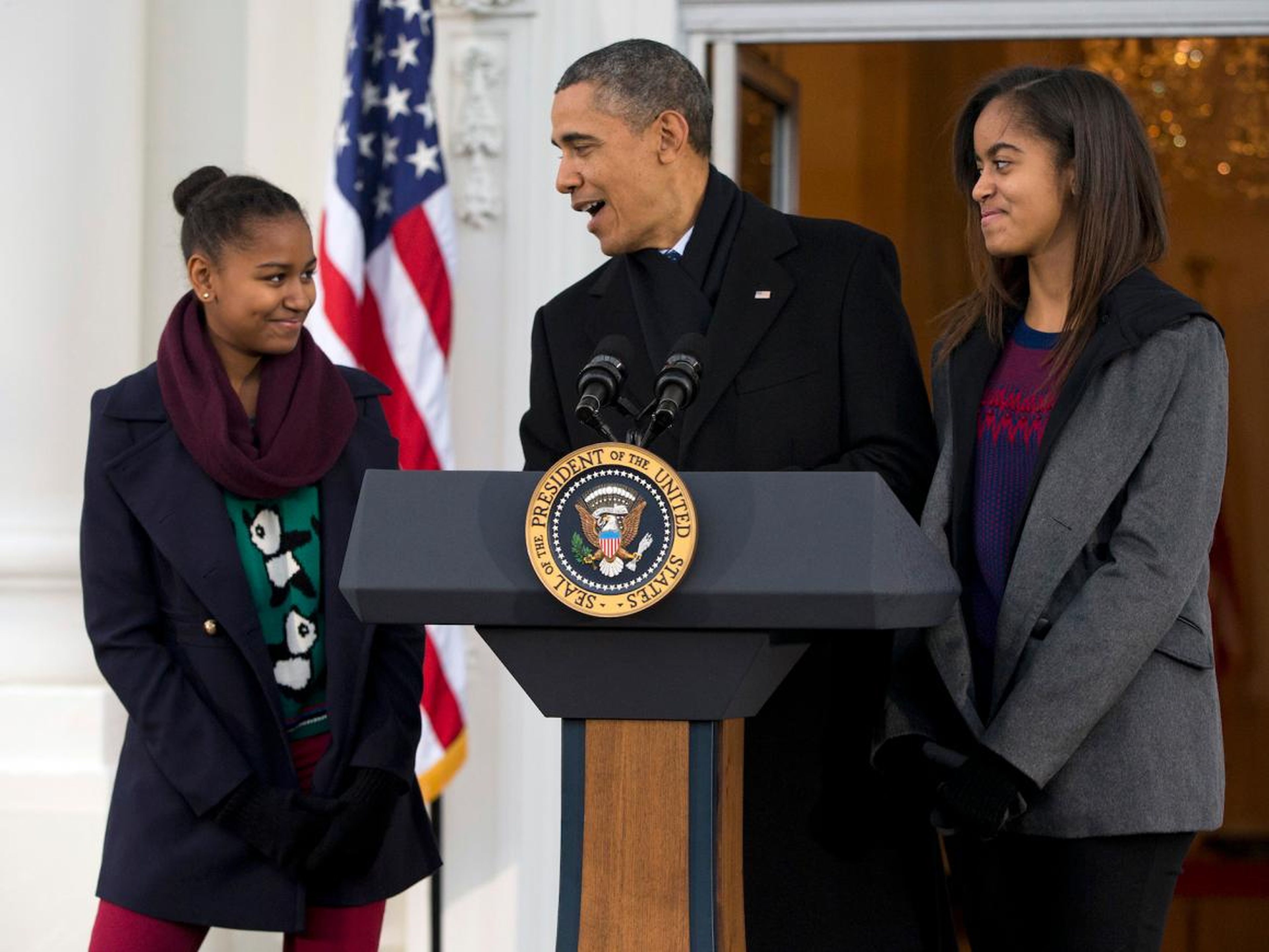 El presidente Barack Obama, con sus hijas Sasha (izq.) y Malia, hace una broma durante el Día de Acción de Gracias de salvar a un pavo de la mesa con un "perdón presidencial" en la Casa Blanca el miércoles 27 de noviembre de 2013 en Washington.